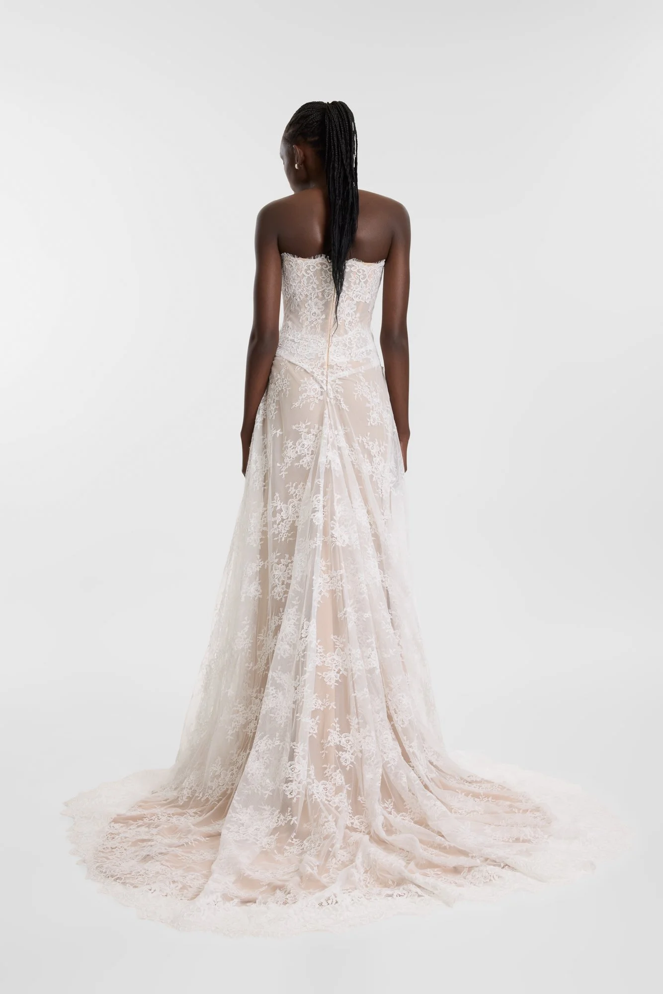 Diaphanous dressing in KYHA Bride Wilton. Constructed by hand-moulding delicate lace, Wilton sees swathes of sheer lace contrast a nude chiffon base for a study in understated impact. A highly structured, corseted bodice boasts a scalloped edge along