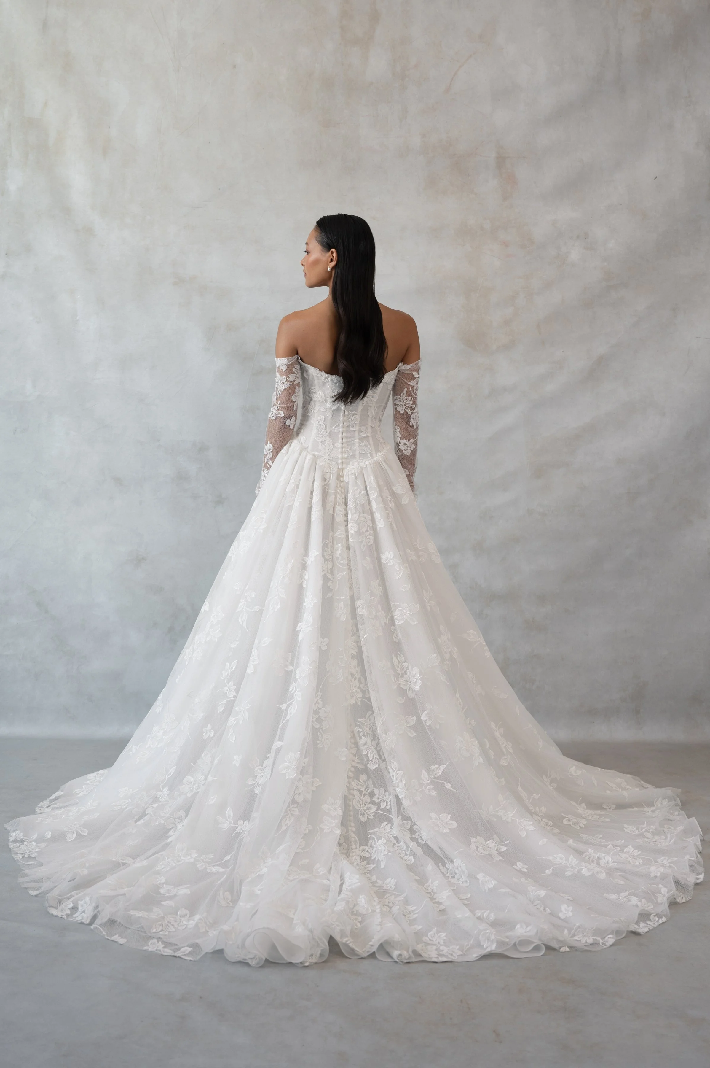 The Jenny Yoo Phoebe gown, cut in our delicately textured Isadora floral embroidery, is as modern as she is romantic. The structured Basque corset bodice leads way to a flowing gathered skirt. Detachable long sleeves lend exciting versatility.