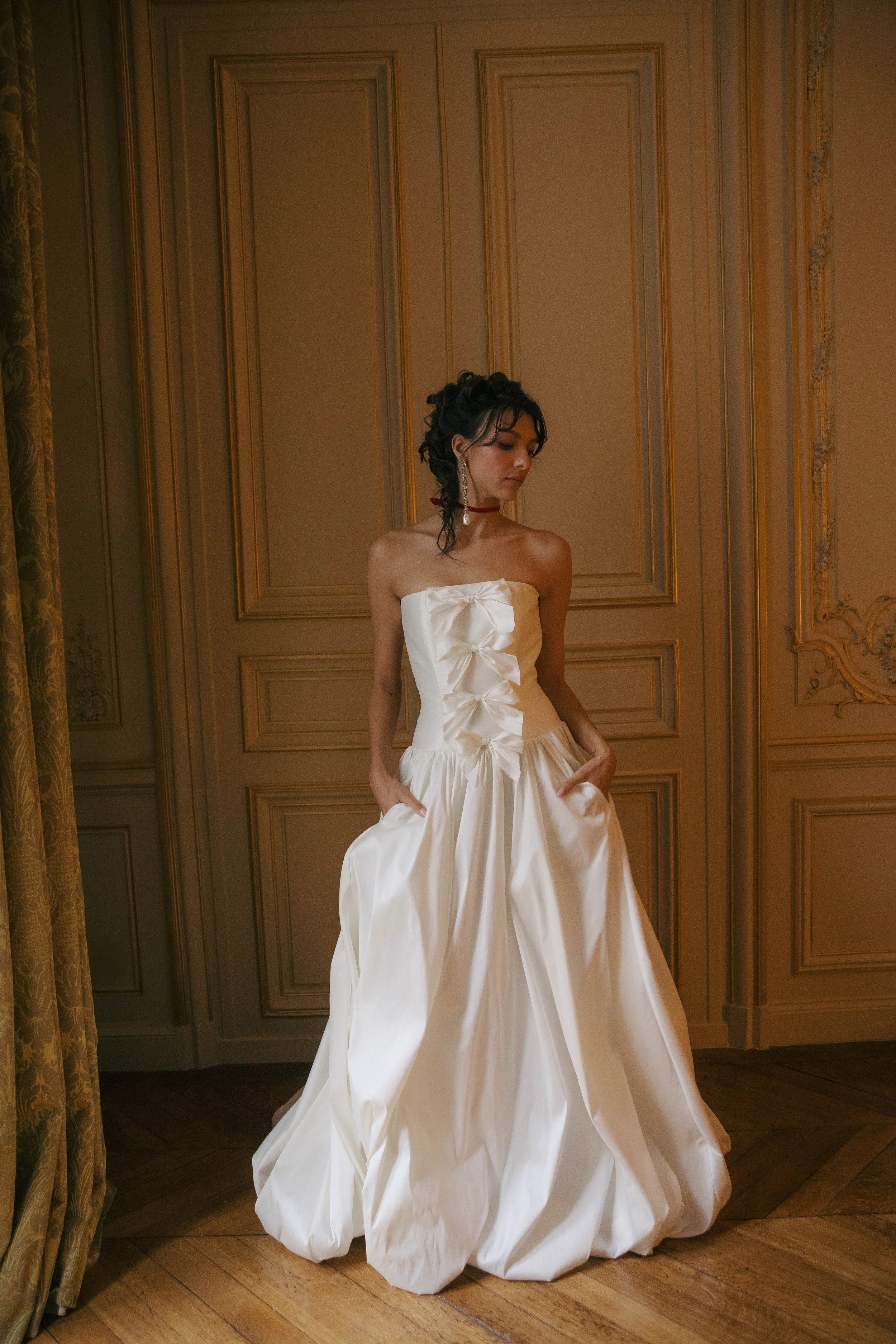 The & For Love Bridal Antoinette gown is a bold fashion-forward statement piece designed for the bride who wants to turn heads. With its striking silhouette, edgy couture details, and expertly crafted structure, this gown blends high-fashion attitude