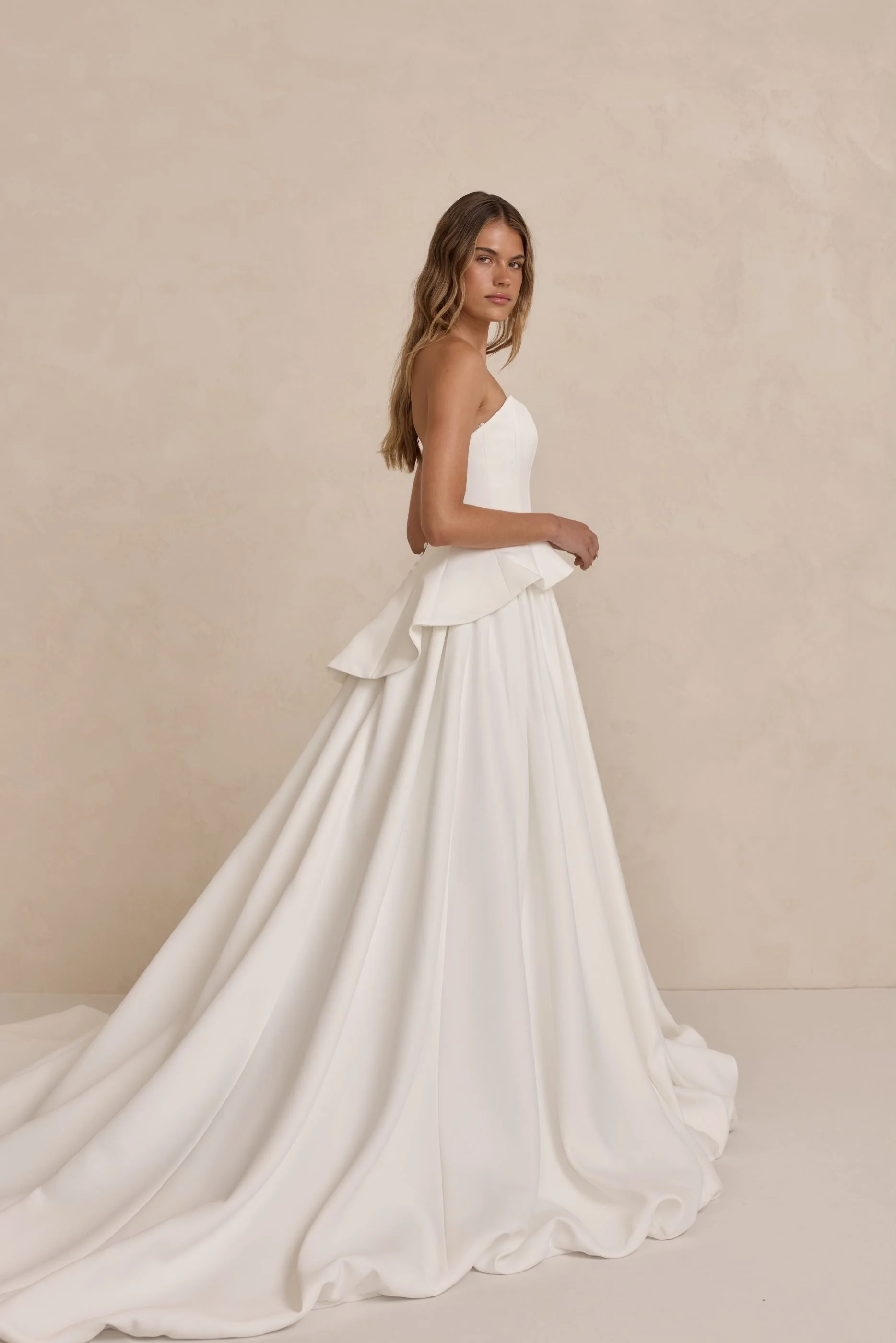 Tanner by MWL, made from our luxurious Avery Satin, the skirt flows beautifully and is finished with a bagged out bubble hem, adding subtle volume and a touch of drama. Inside the bodice, interfacing provides extra support, ensuring a secure and eleg