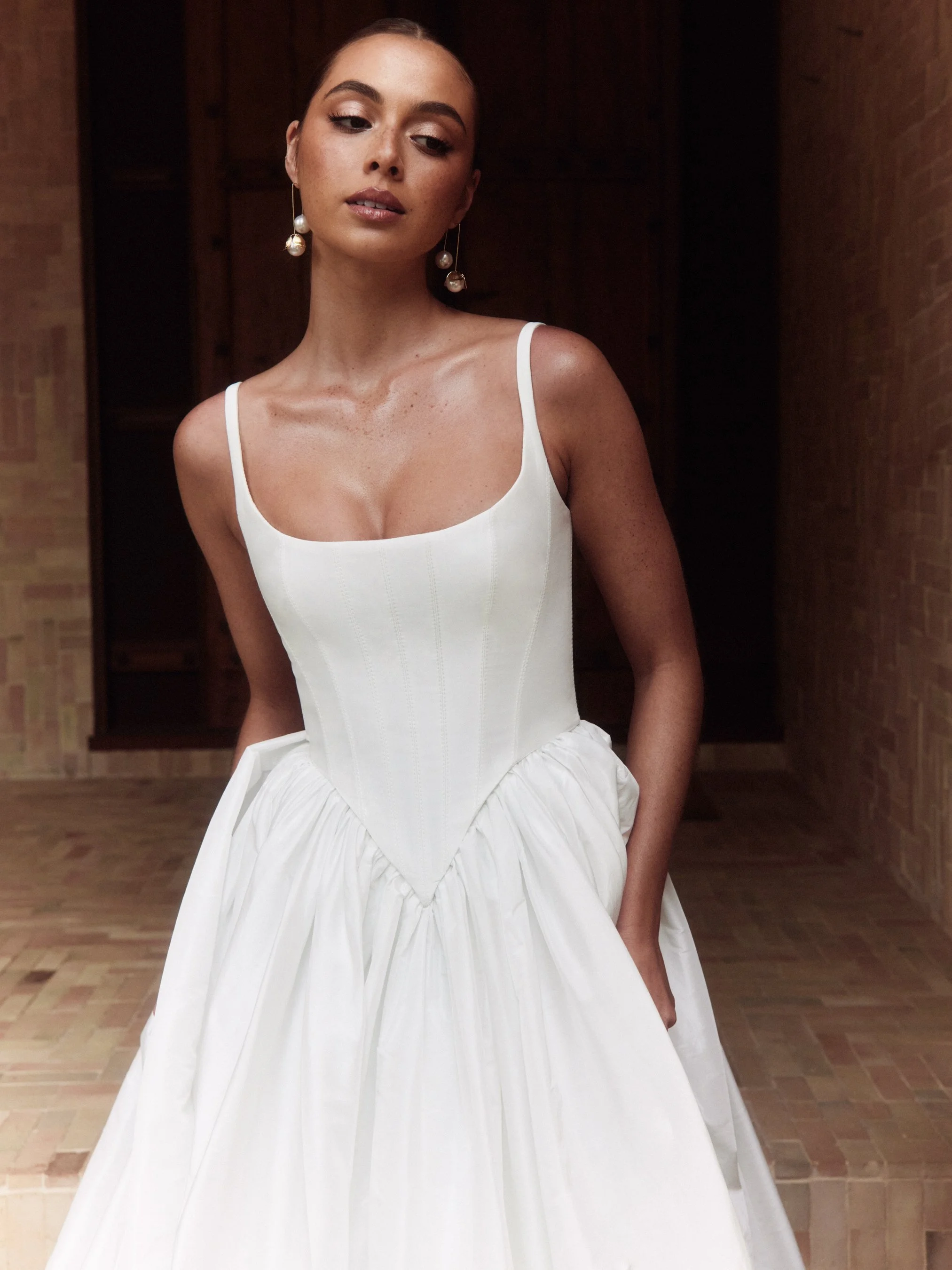 The Alena Leena Bridal protea gown: The basque corset cinches at the waist, creating that coveted hourglass shape that's so in right now. With its soft square neckline, this gown brings a fresh, modern vibe to traditional elegance. Plus, our heavily 