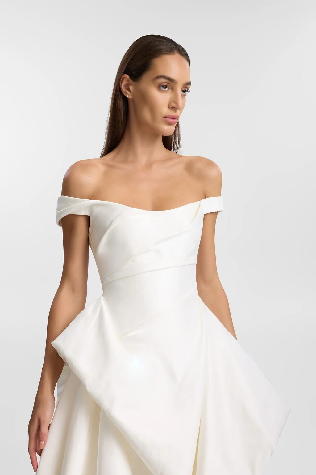 Cool girls wear KYHA Bride Willis. Luxe ivory silk satin is directionally draped across the front bodice and crafted into architectural side folds in a celebration of the female form. A full draped skirt and a sweeping train create a more-is-more sta