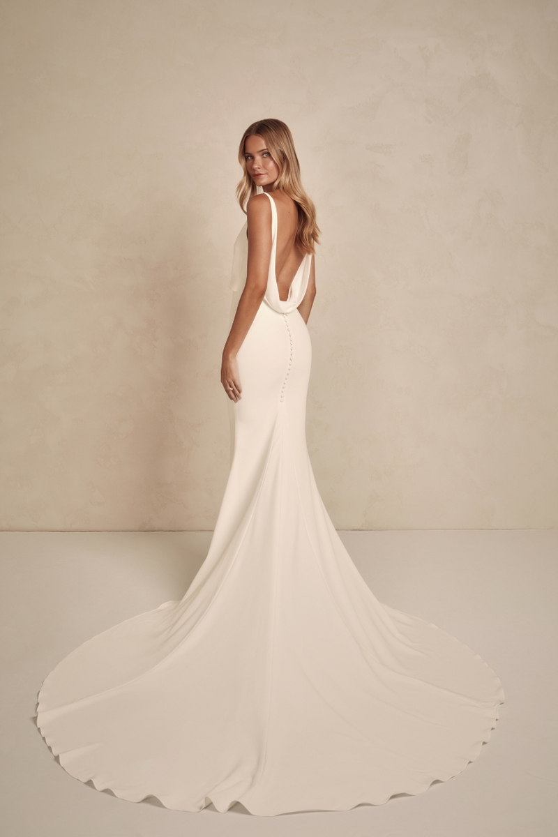 Austin offers a modern twist on a classic MWL design, combining the best elements into one timeless, flattering crepe dress. This elegant yet alluring gown features a delicate drape at the waist, enhancing its sleek, figure-hugging silhouette.