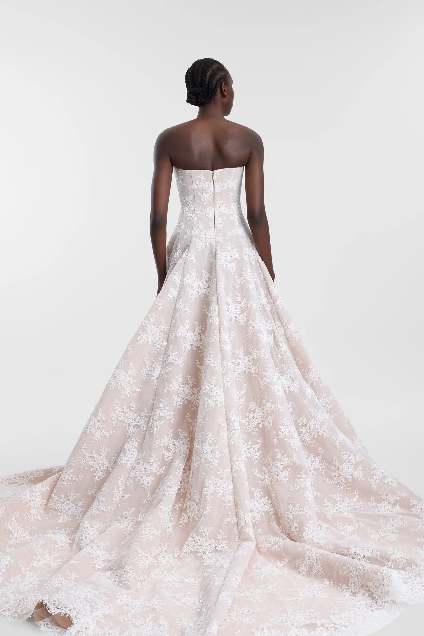 Laced with ethereal romance in KYHA Bride Dalias. A modern take with old-world energy, Dalias is crafted from intricate corded white lace with a chiffon underlay and a scalloped lace trim at the hem. The strapless structured bodice and full skirt and