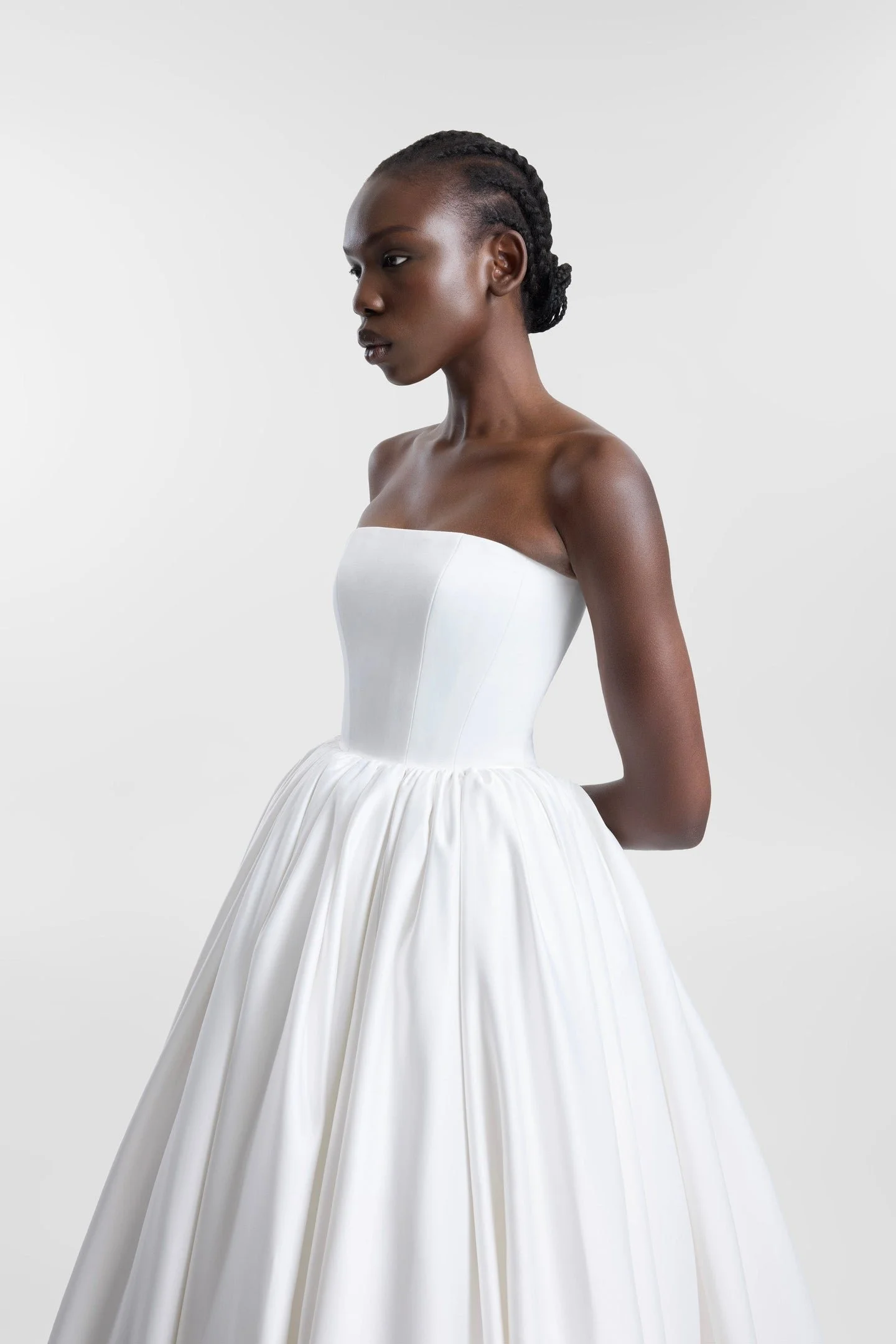 Clean lines, dramatic proportions and more than a touch of je ne sais quoi define KYHA Bride Cleo. A minimalist reinvention of the traditional ballgown, Cleo's clean, strapless bodice is defined by a modern straight neckline and unexpected low-dipped