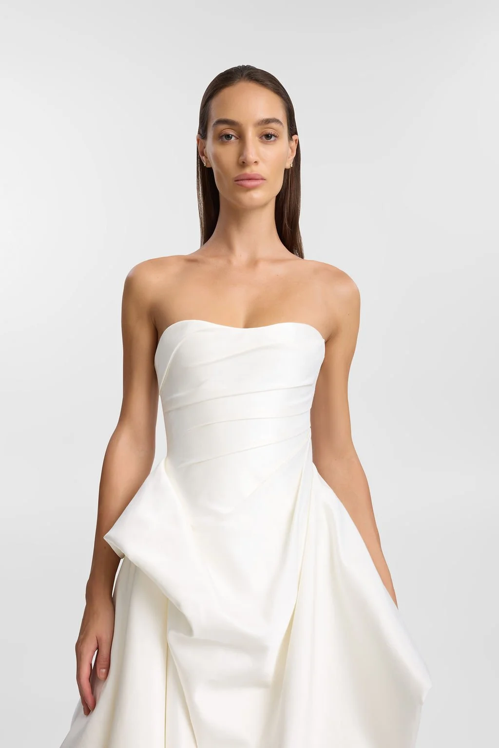 KYHA Bride Preston: an ode to eras past. A fresh take on tradition, Preston brings a modern edge thanks to its structural draping, showstopping train and architectural dropped waist. Crafted from luxe silk satin, Preston’s strapless silhouette, struc