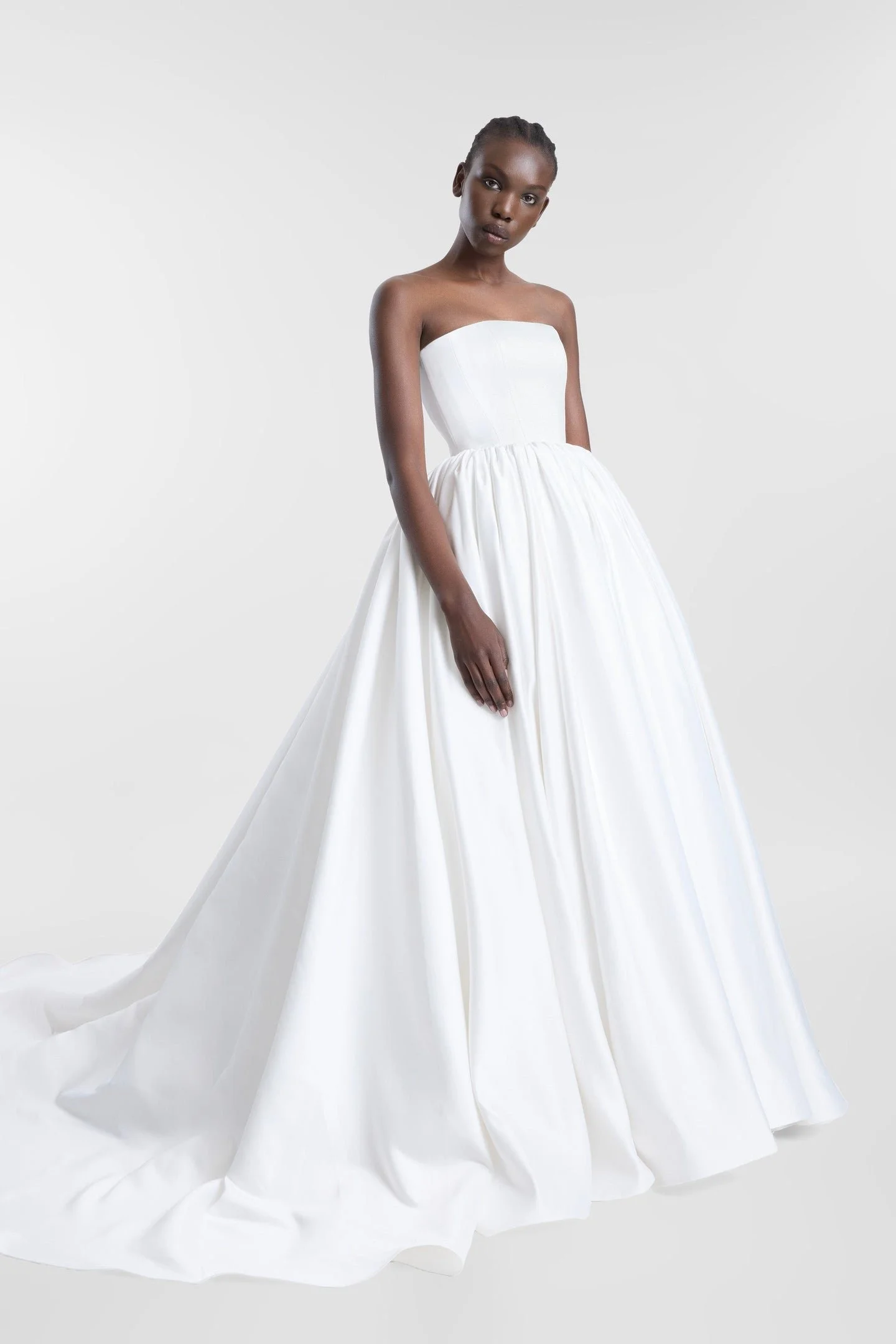Clean lines, dramatic proportions and more than a touch of je ne sais quoi define KYHA Bride Cleo. A minimalist reinvention of the traditional ballgown, Cleo's clean, strapless bodice is defined by a modern straight neckline and unexpected low-dipped