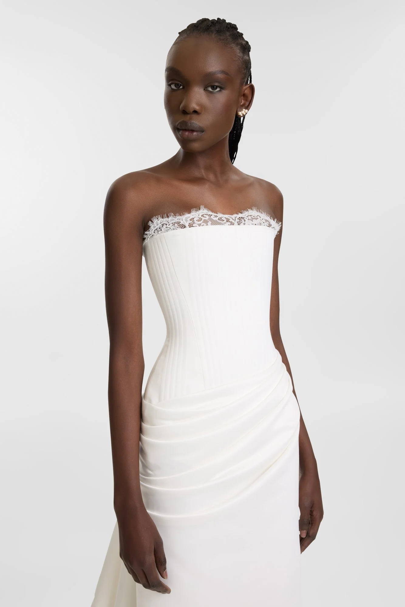 Celebrate the finer things in KYHA Bride Eaton. A structured drop waist bodice reveals fine details in a soft lace trim at the neckline and boning channels designed to draw in the eye. An asymmetric drape sweeps across the hip into a fluid column ski