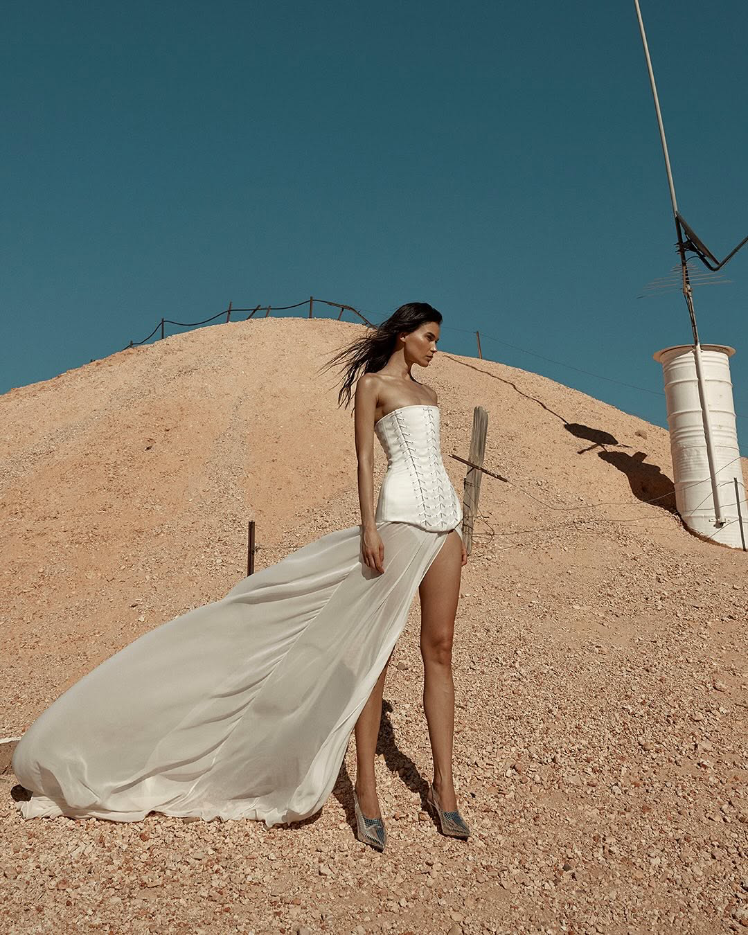 The sheer power of Bassett. Ethereal yet grounded in strength, Bassett is crafted from light layers of chiffon to see you float through your big day. Featuring a statement split, pair Bassett with the Ford corset for the ultimate in dichotomous dress