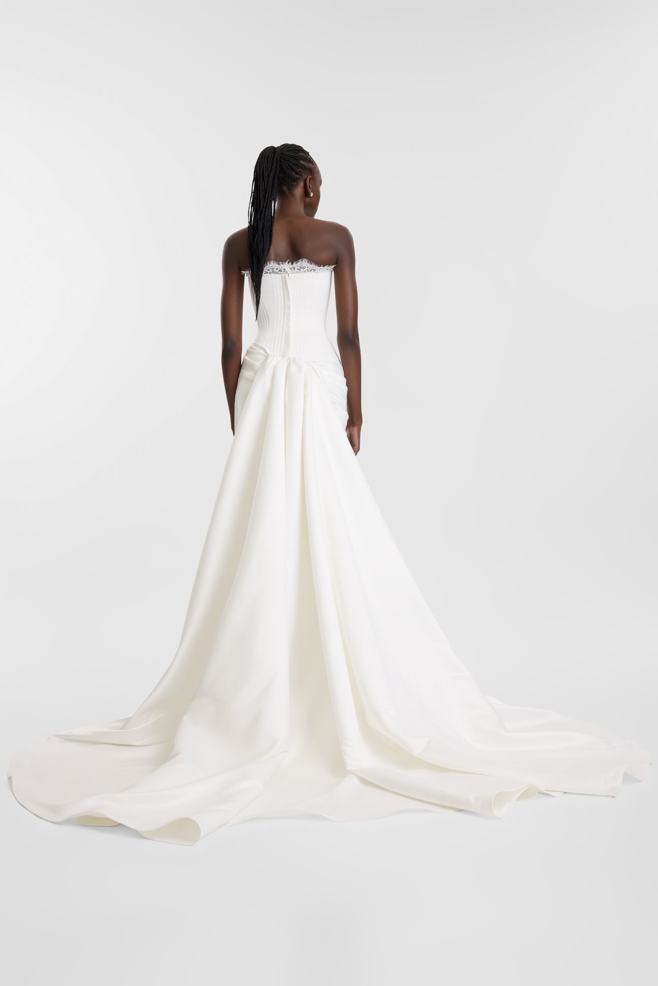 Celebrate the finer things in KYHA Bride Eaton. A structured drop waist bodice reveals fine details in a soft lace trim at the neckline and boning channels designed to draw in the eye. An asymmetric drape sweeps across the hip into a fluid column ski