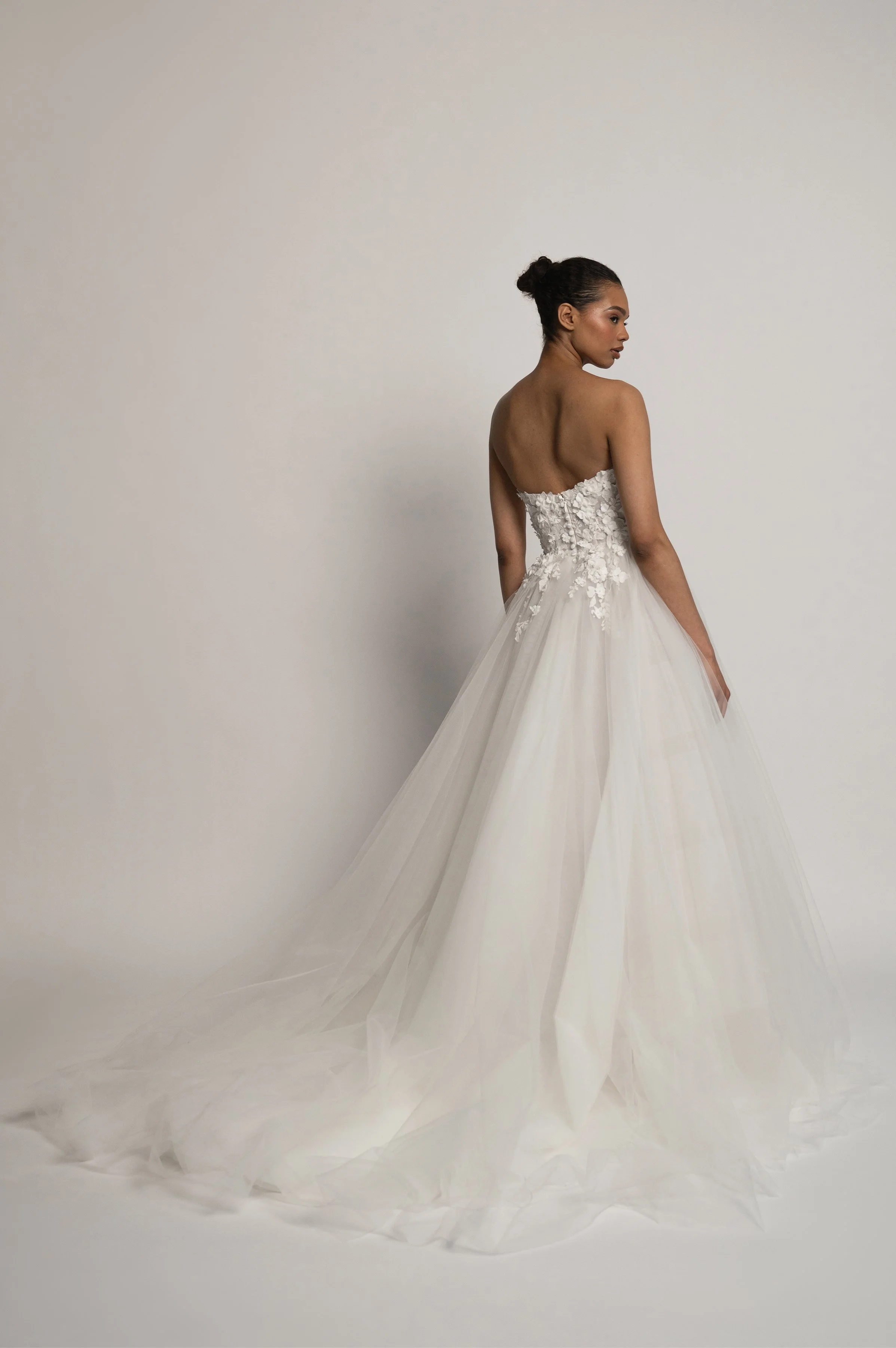 The Jenny Yoo Bridal Romy: Delicate yet dimensional floral appliques adorn a corseted bodice and lead to a full, frothy tulle skirt, the Romy gown is a true romantic. Stocked at Halo and Wren Bridal.