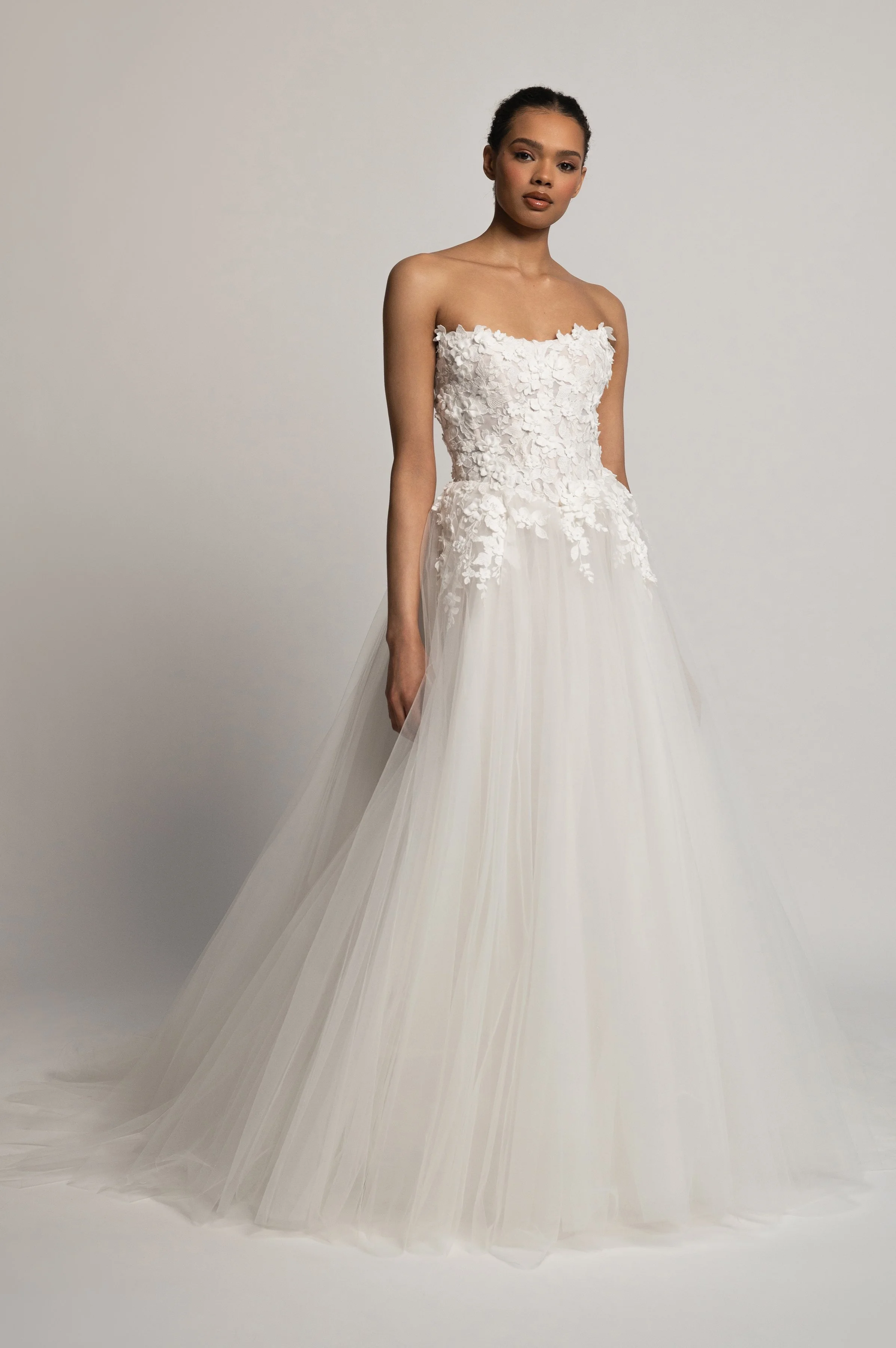 The Jenny Yoo Bridal Romy: Delicate yet dimensional floral appliques adorn a corseted bodice and lead to a full, frothy tulle skirt, the Romy gown is a true romantic. Stocked at Halo and Wren Bridal.