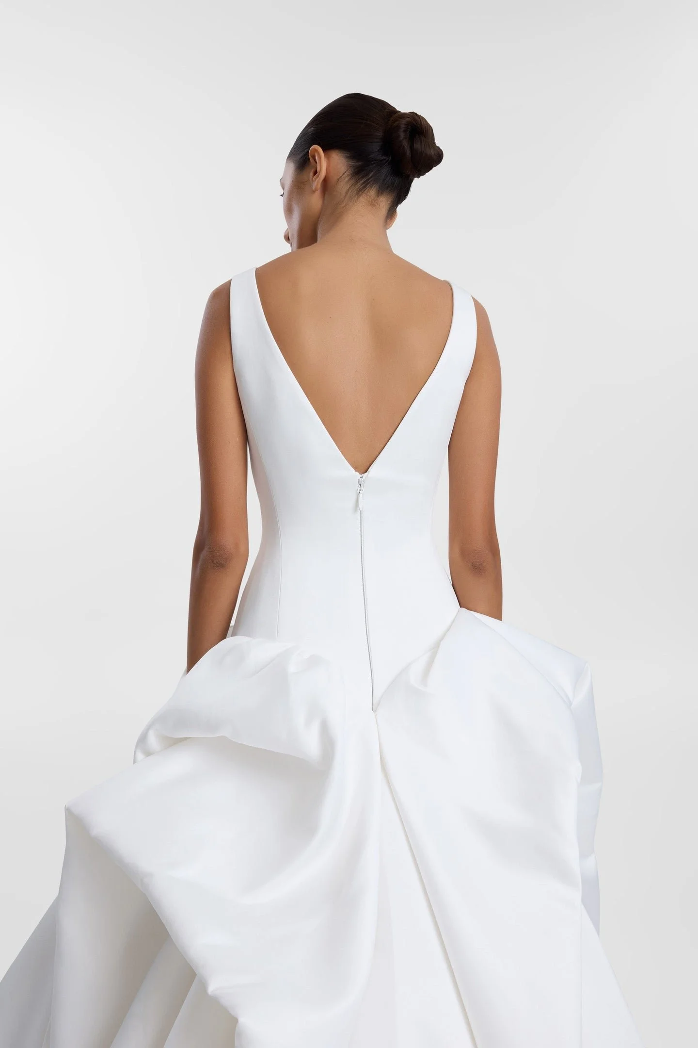 Drama takes shape in KYHA Bride Bailey at Halo + Wren. A directional take on the classic ballgown, Bailey is crafted from lustrous duchess satin and defined by artfully placed, architectural draping. Sculptural folds play with light and bring dimensi