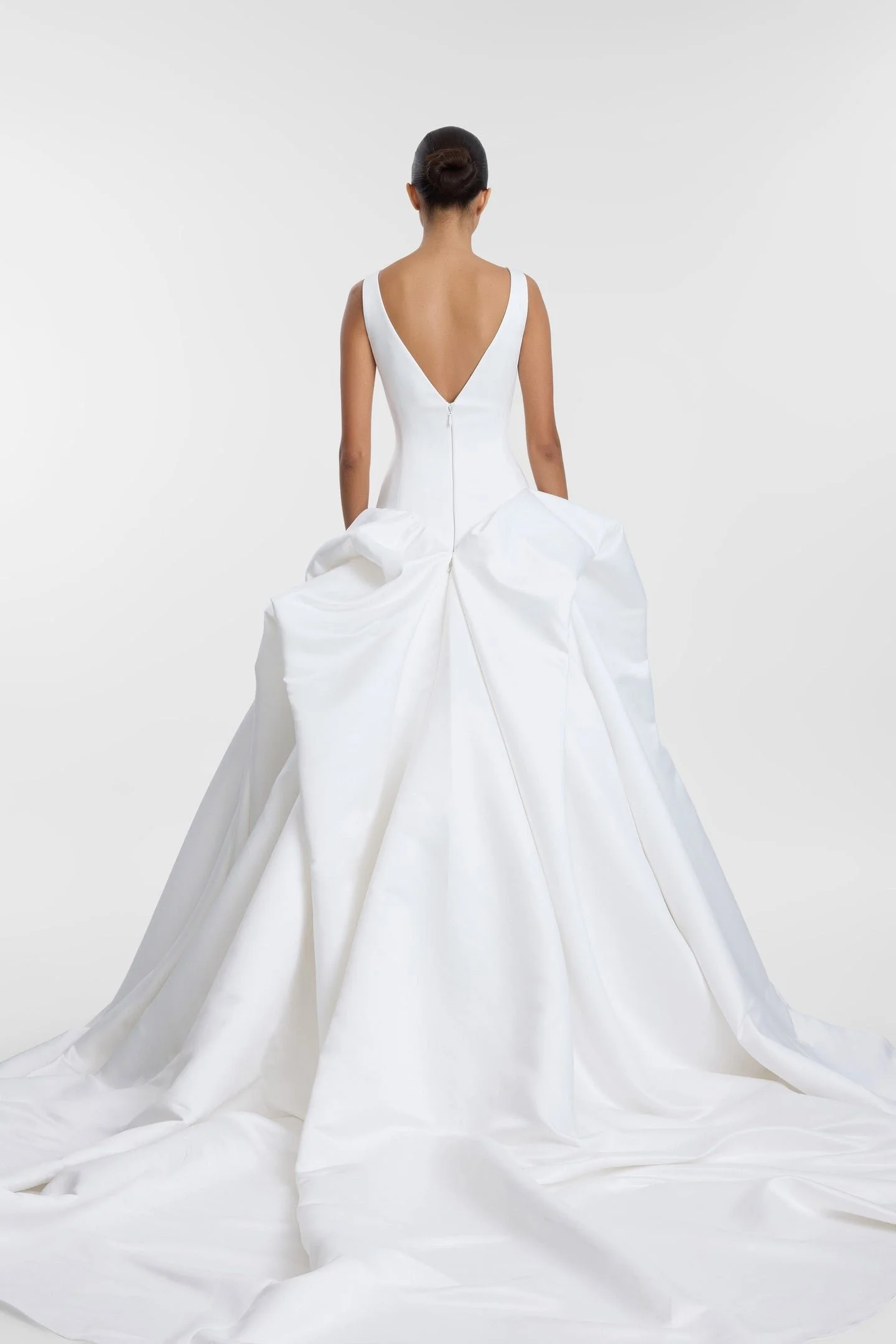 Drama takes shape in KYHA Bride Bailey at Halo + Wren. A directional take on the classic ballgown, Bailey is crafted from lustrous duchess satin and defined by artfully placed, architectural draping. Sculptural folds play with light and bring dimensi