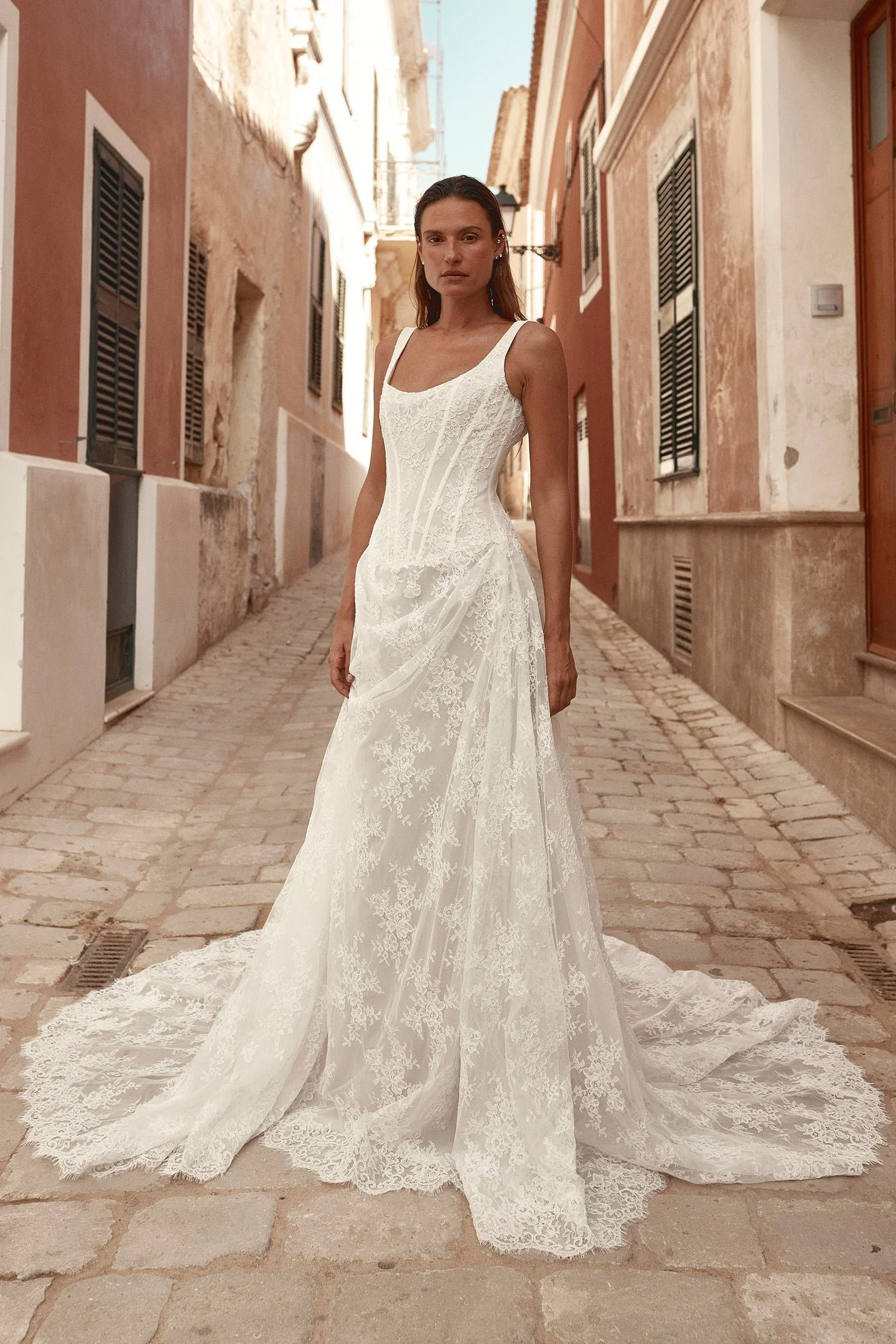 Old world charm meets modern moments in Joni. Imbued with classic appeal, Joni features an A-line silhouette with a scoop neckline, a corseted bodice, shoulder straps and a draped skirt. Corded lace is sculpted across the bodice and effortlessly drap