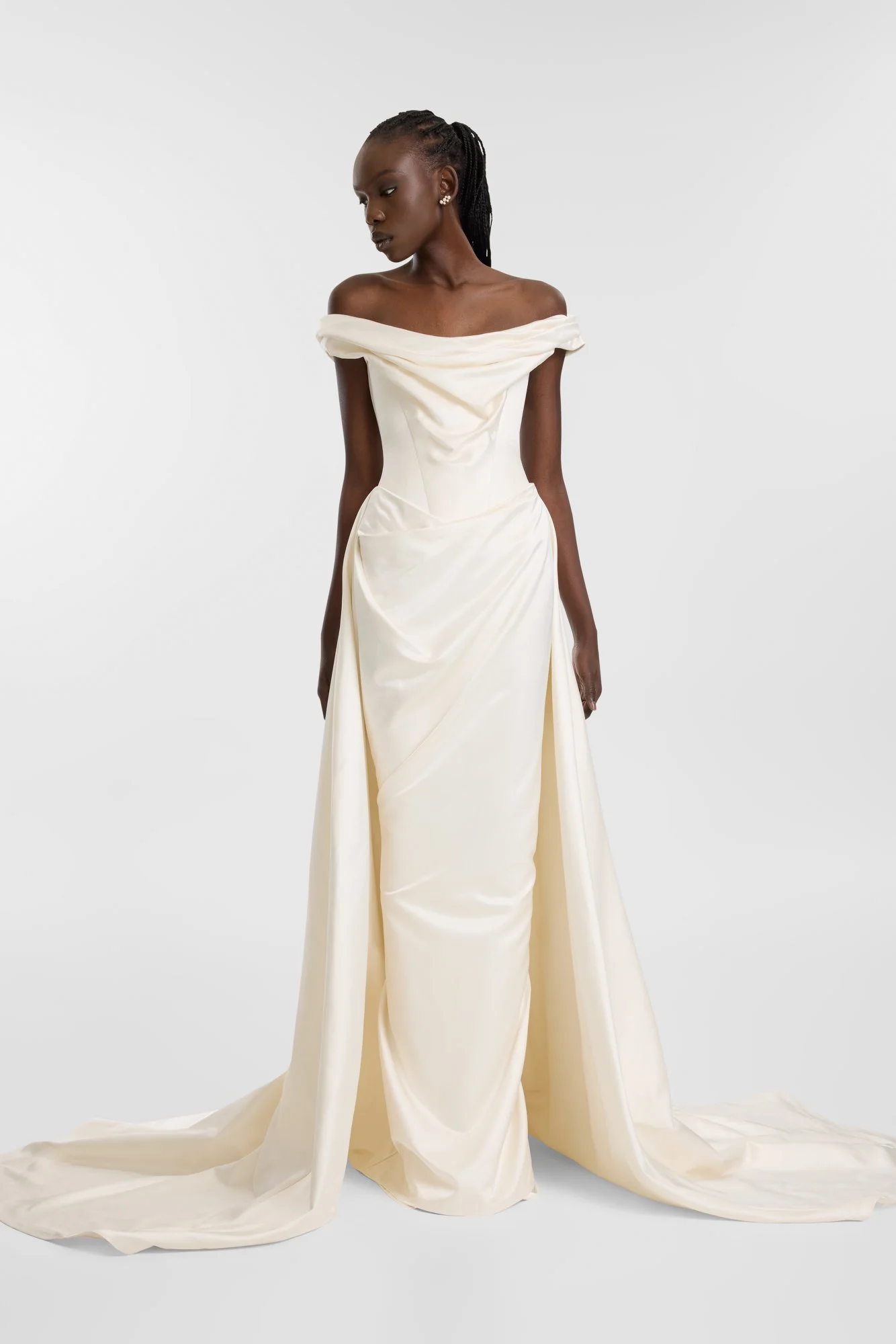 Past and present collide in KYHA BRIDE Blyth. Introducing a new and luxurious creamy silk satin, KYHA Bride Blyth gown is a fresh take on a classic. Its off-shoulder, draped and highly structured corset cinches the waist and its soft column front ski