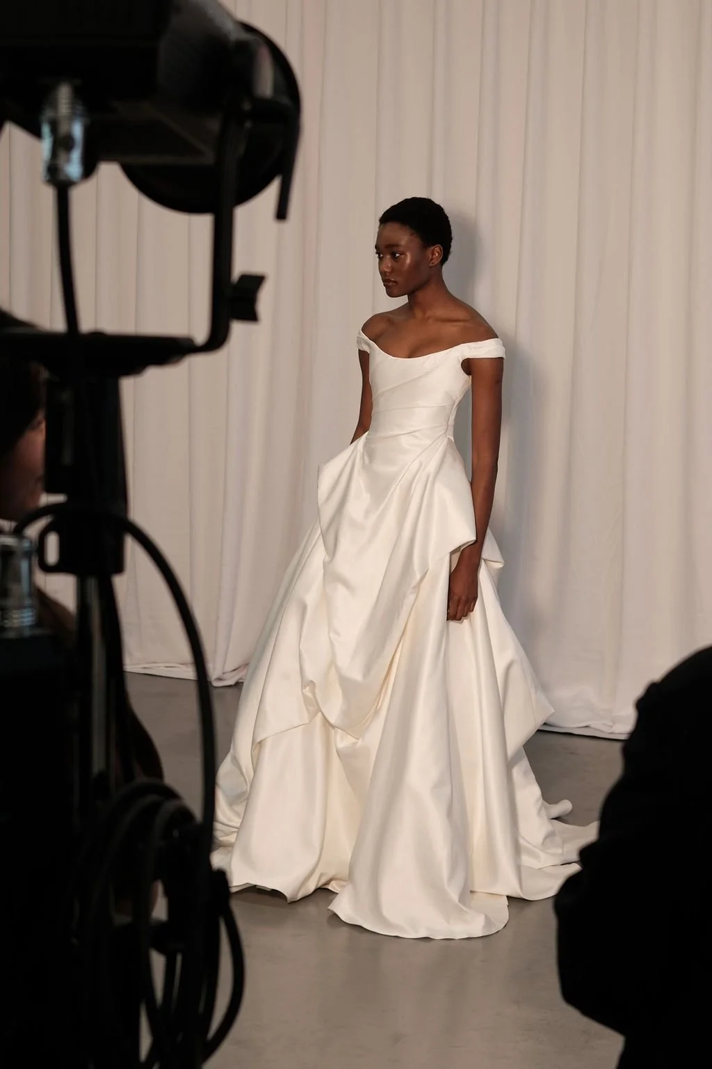 Cool girls wear KYHA Bride Willis. Luxe ivory silk satin is directionally draped across the front bodice and crafted into architectural side folds in a celebration of the female form. A full draped skirt and a sweeping train create a more-is-more sta