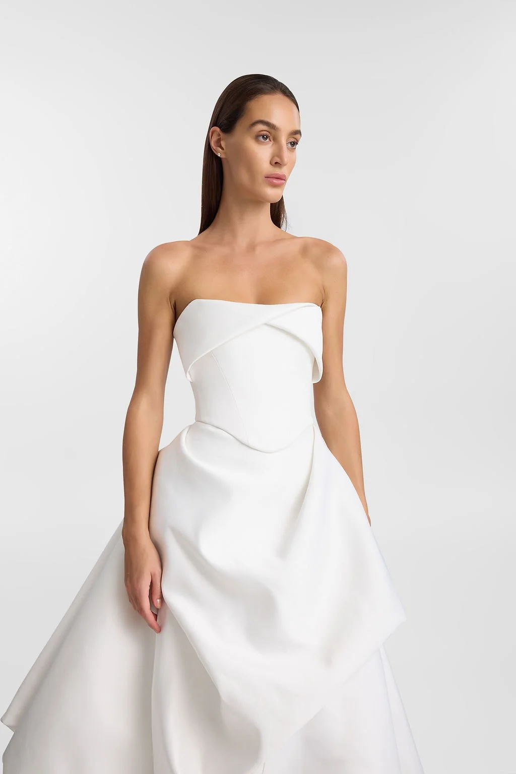 On cloud nine in KYHA Bride Lowe. Designed from lustrous duchess satin, Lowe’s bold focus on shape and head-turning structural draping creates soft, cloud-like moments. Featuring a sculpted waistband and a floor-grazing full skirt with internal netti