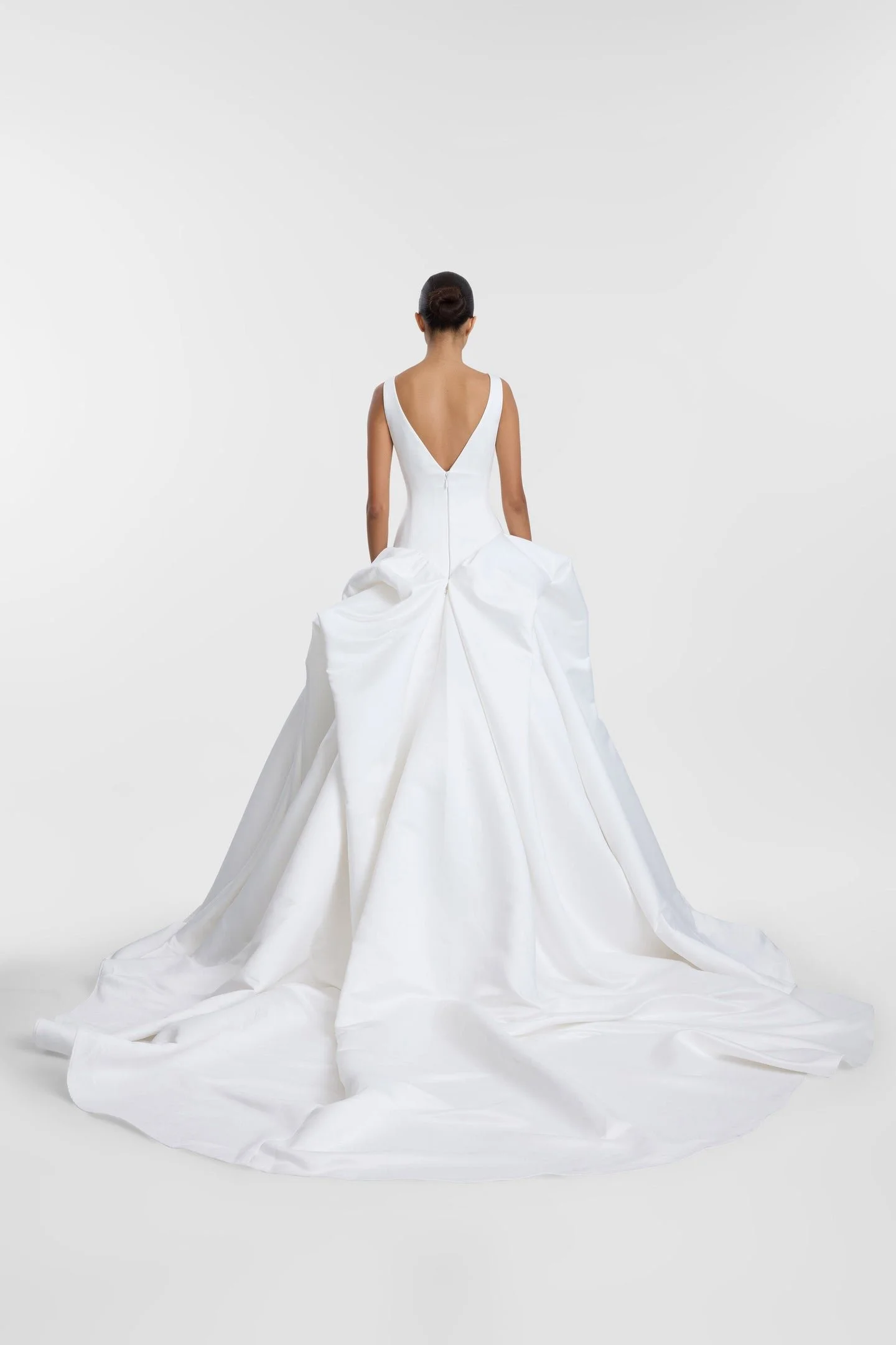 Drama takes shape in KYHA Bride Bailey at Halo + Wren. A directional take on the classic ballgown, Bailey is crafted from lustrous duchess satin and defined by artfully placed, architectural draping. Sculptural folds play with light and bring dimensi