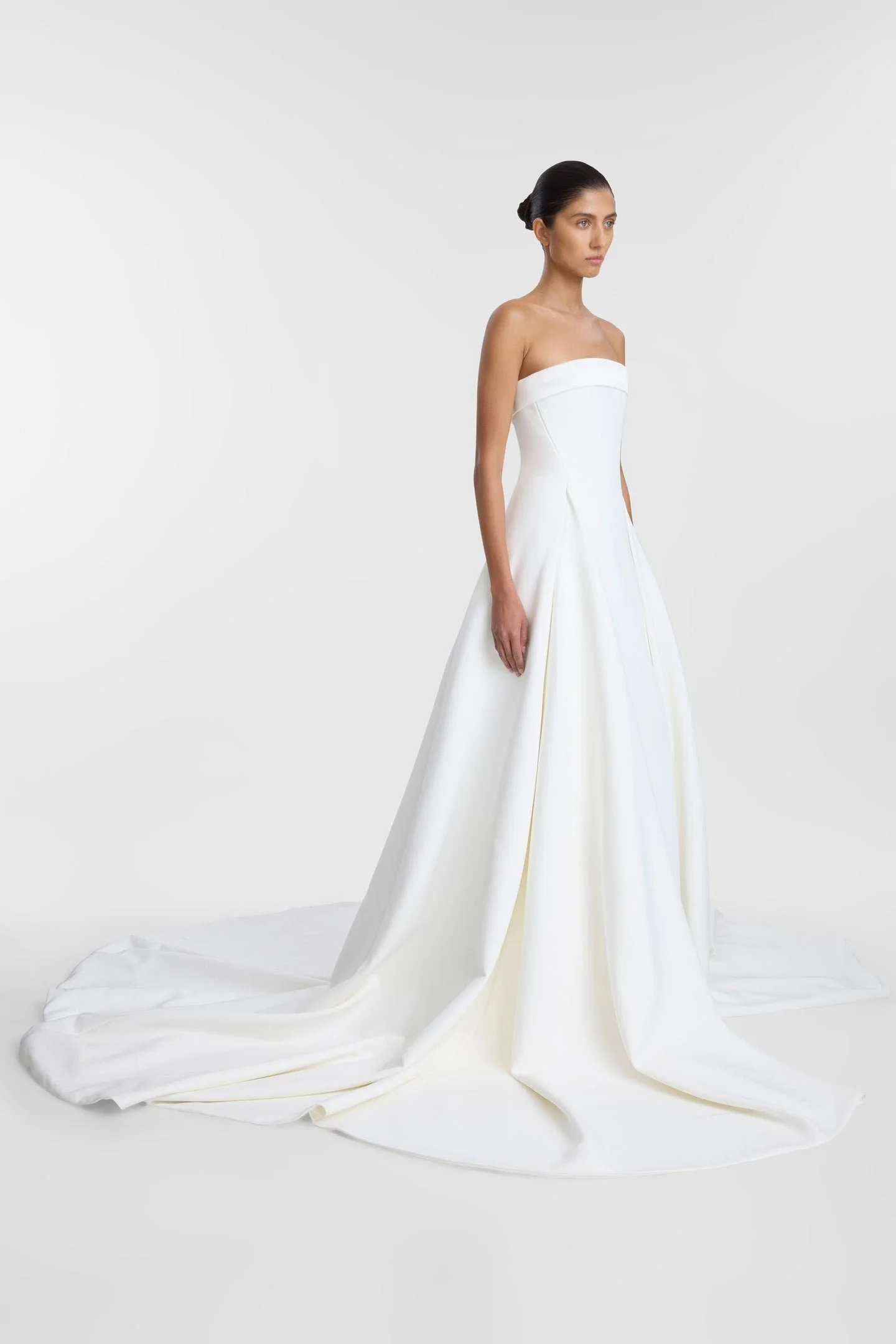Invigorate your timeless aesthetic with KYHA BRIDE Matí. Reinventing a classic A-line, Matís cinched waist and sculpted godets create column definition at the front of the skirt. Crafted from bonded crepe, Matí features a straight neckline and rule-b