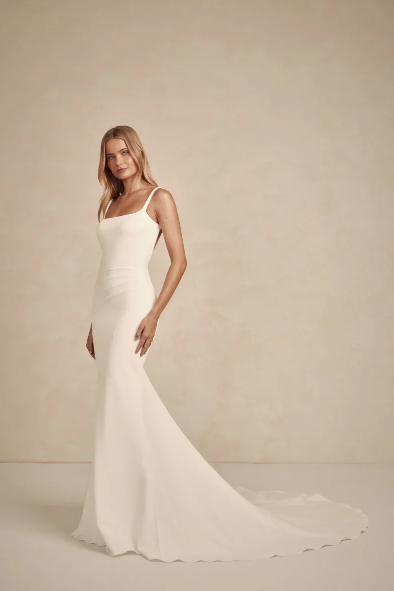MWL Bridal Gracie is the embodiment of quiet luxury and modern minimalism. Crafted from our luxurious French Crepe, her subtle square neckline and delicate straps frame the shoulders with effortless grace. The silhouette is softly sculpted, with cons