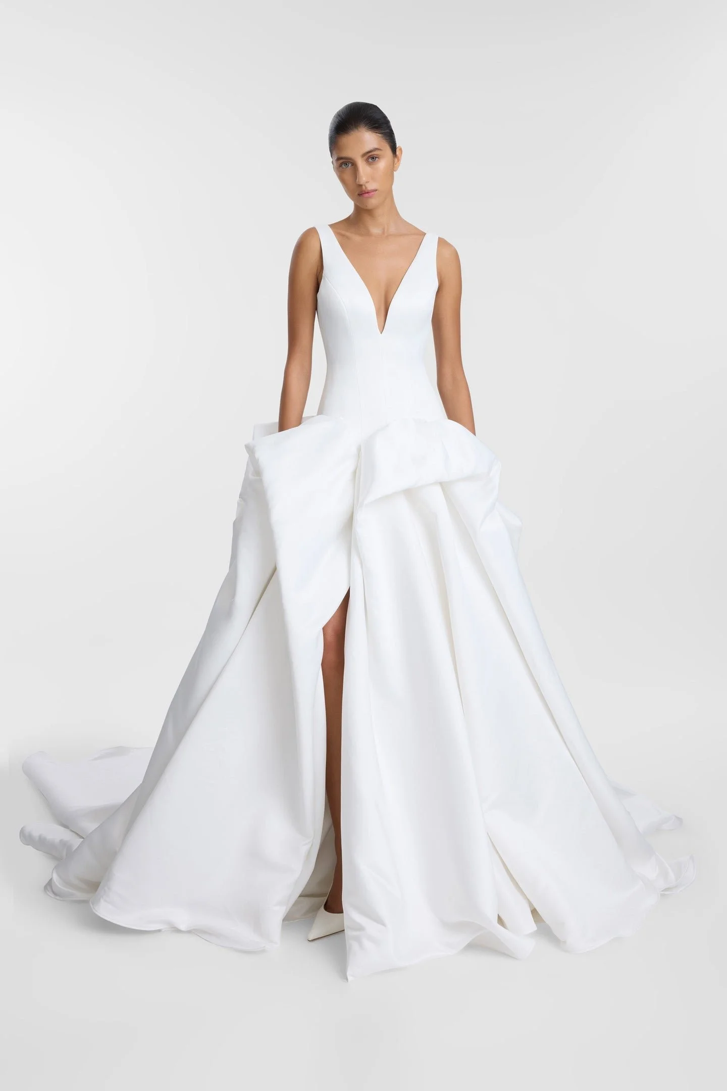 Drama takes shape in KYHA Bride Bailey at Halo + Wren. A directional take on the classic ballgown, Bailey is crafted from lustrous duchess satin and defined by artfully placed, architectural draping. Sculptural folds play with light and bring dimensi