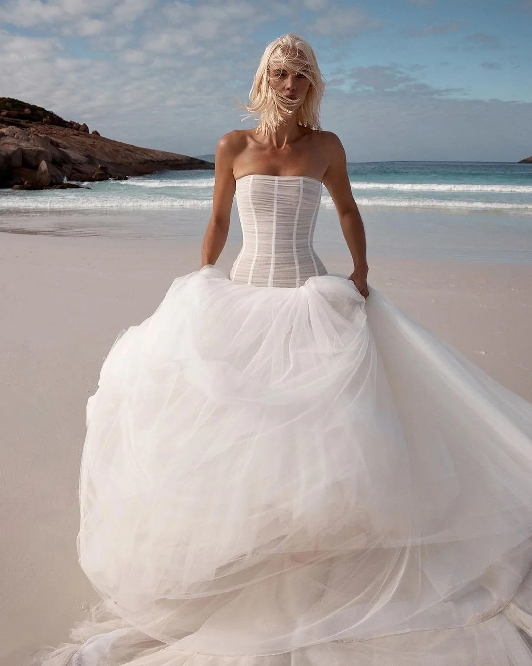 Balletcore energy en pointe via KYHA Bride Beau. Its structured, dropped waist bodice is artfully draped with soft tulle, but it’s the full, gathered skirt that delivers the kind of drama that is usually reserved for the stage