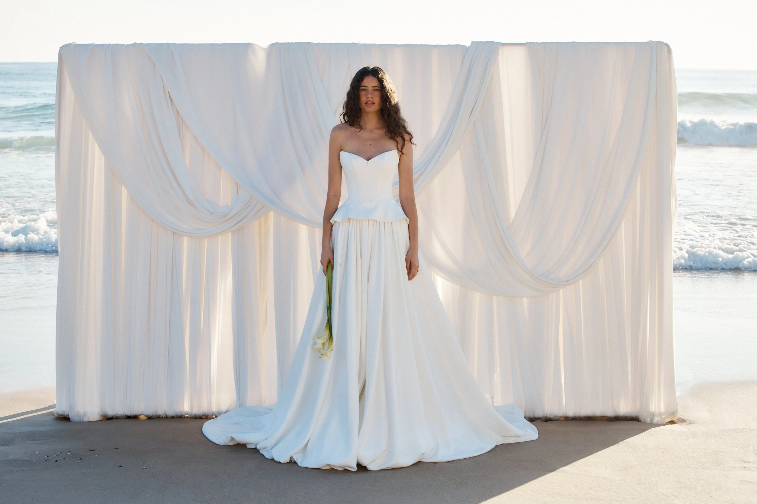 Tanner by MWL, made from our luxurious Avery Satin, the skirt flows beautifully and is finished with a bagged out bubble hem, adding subtle volume and a touch of drama. Inside the bodice, interfacing provides extra support, ensuring a secure and eleg