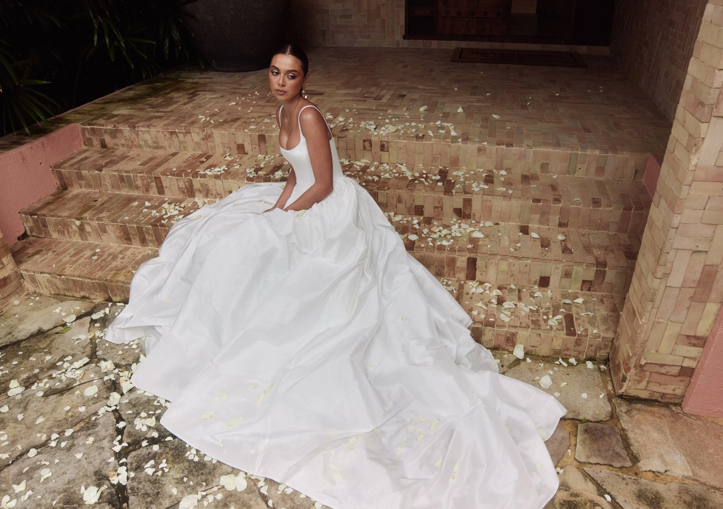The Alena Leena Bridal protea gown: The basque corset cinches at the waist, creating that coveted hourglass shape that's so in right now. With its soft square neckline, this gown brings a fresh, modern vibe to traditional elegance. Plus, our heavily 