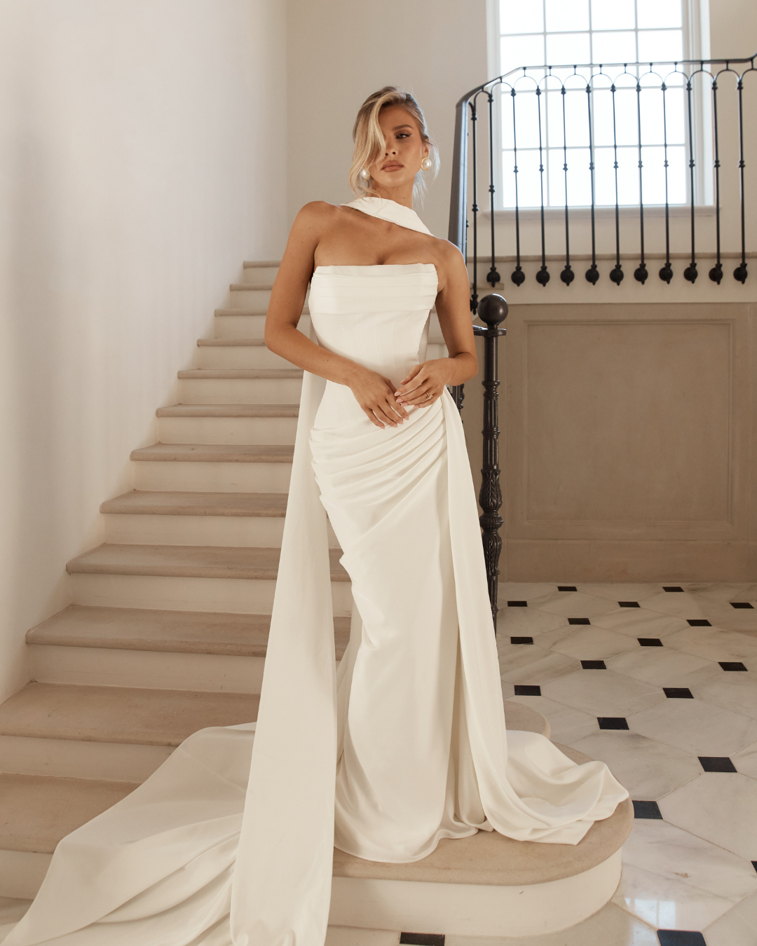 Jane Hill Bridal Mont Blanc is designed for the bride who loves clean lines with couture-level detail. The structured bodice features subtle texturing across the bust, flowing into a dropped waist that elongates the silhouette. Soft ruching sweeps ac