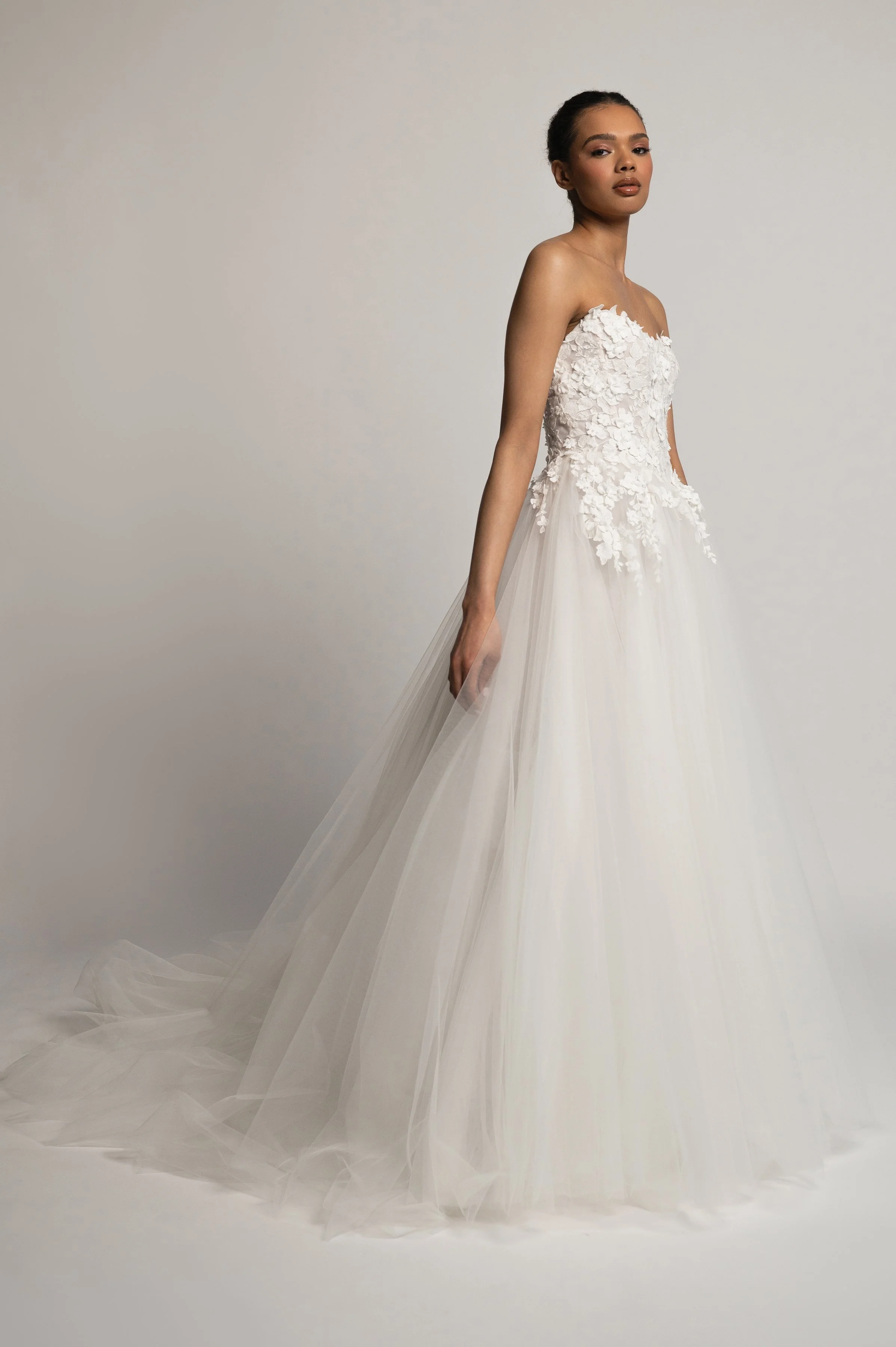 The Jenny Yoo Bridal Romy: Delicate yet dimensional floral appliques adorn a corseted bodice and lead to a full, frothy tulle skirt, the Romy gown is a true romantic. Stocked at Halo and Wren Bridal.