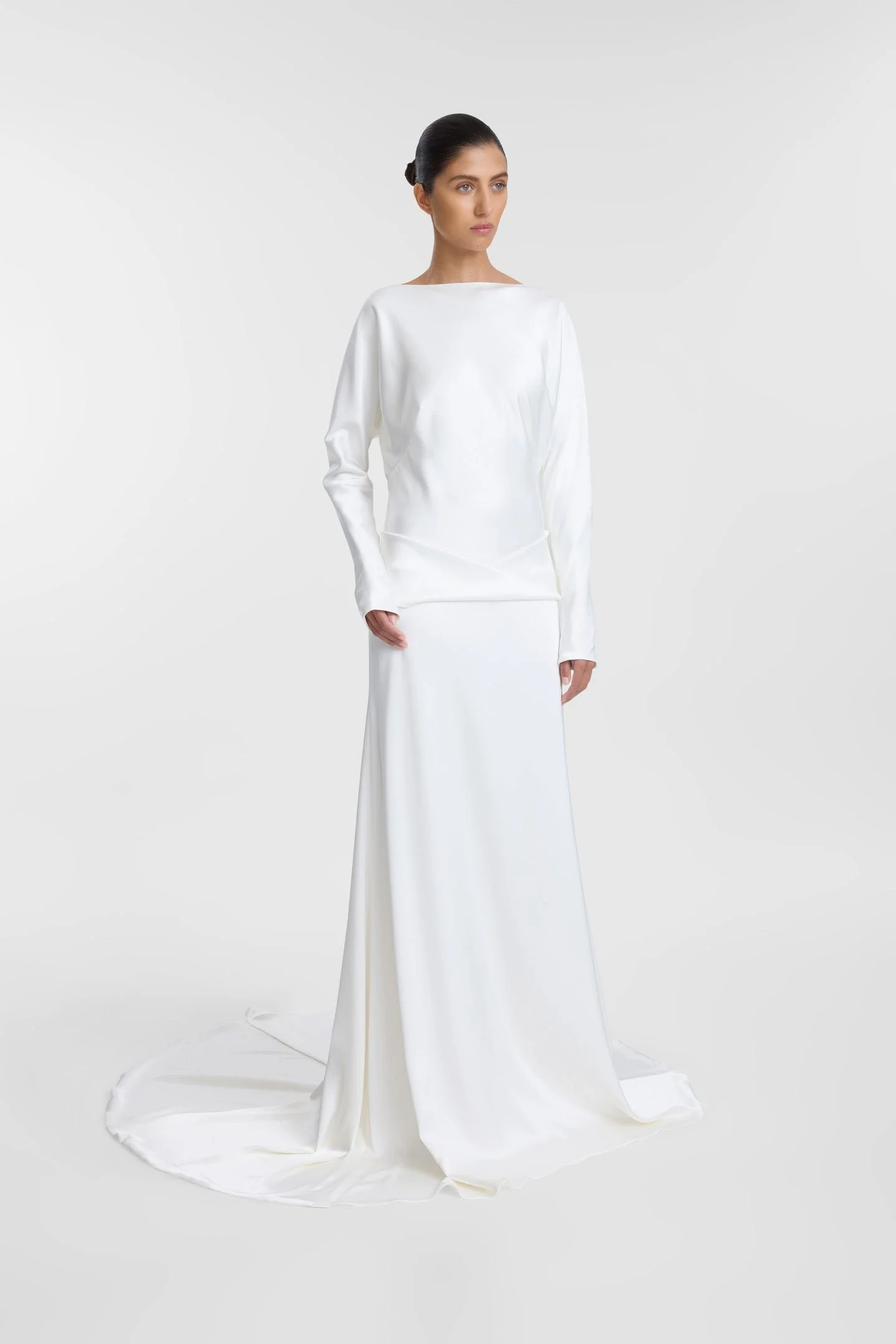 Meet KYHA Bride Lola, spirit of the 70s that will live in your head rent-free. Cut for a slightly oversized fit in luxe double satin, Lola features long batwing sleeves, a twisted sash at the hip, and a skirt with a soft train. The open back adds an 