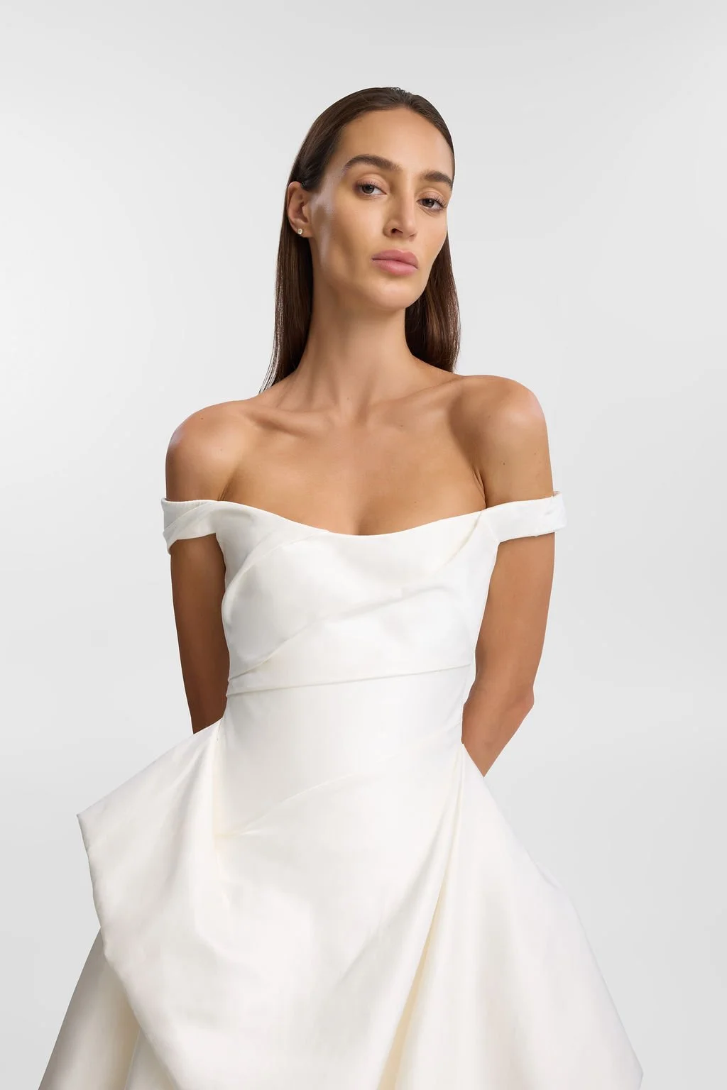Cool girls wear KYHA Bride Willis. Luxe ivory silk satin is directionally draped across the front bodice and crafted into architectural side folds in a celebration of the female form. A full draped skirt and a sweeping train create a more-is-more sta
