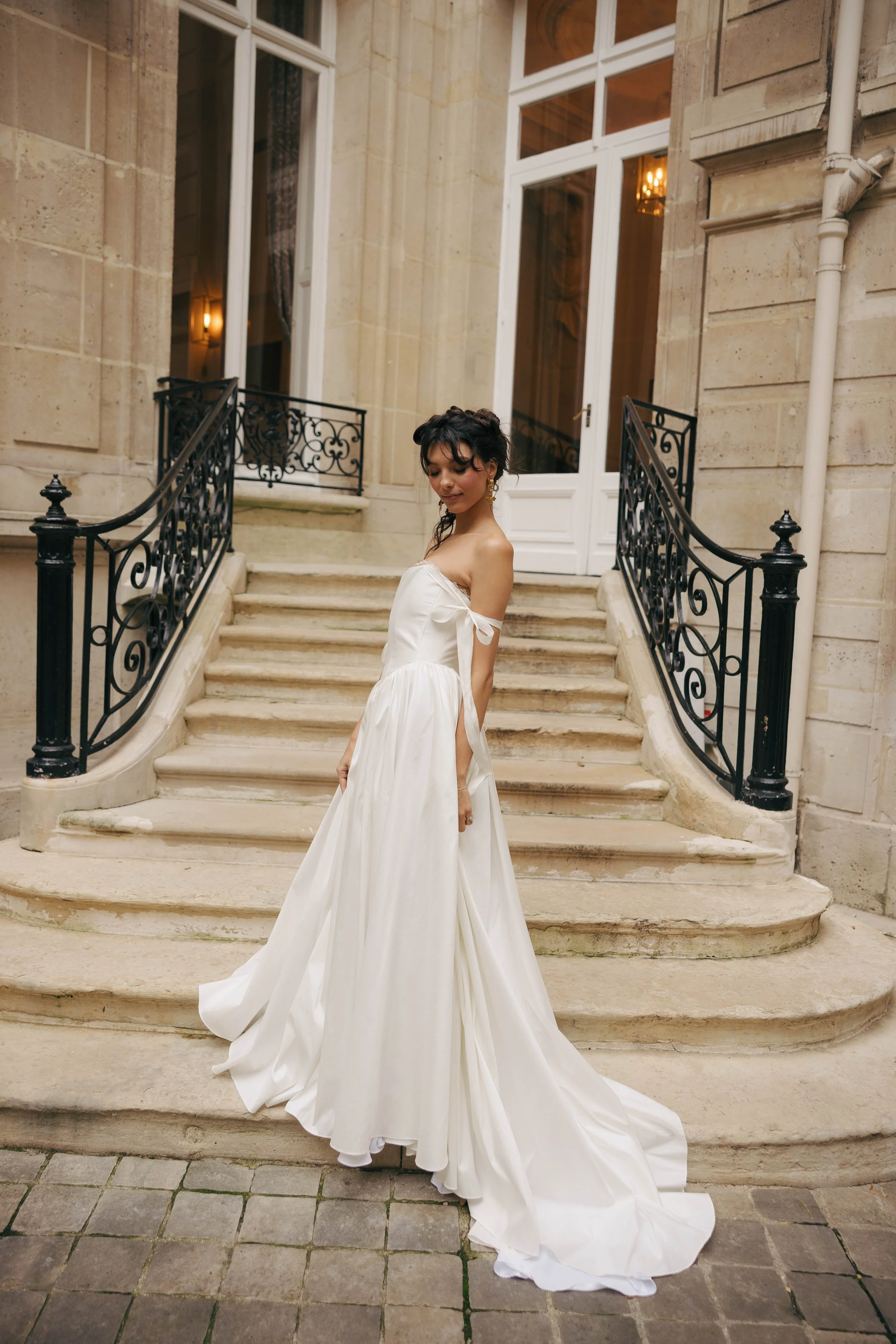 The & For Love Bridal Louis XVI gown is a striking blend of modern elegance and regal inspiration. Designed for the fashion-forward bride, this couture wedding dress features clean lines, refined structure, and a contemporary silhouette that feels bo