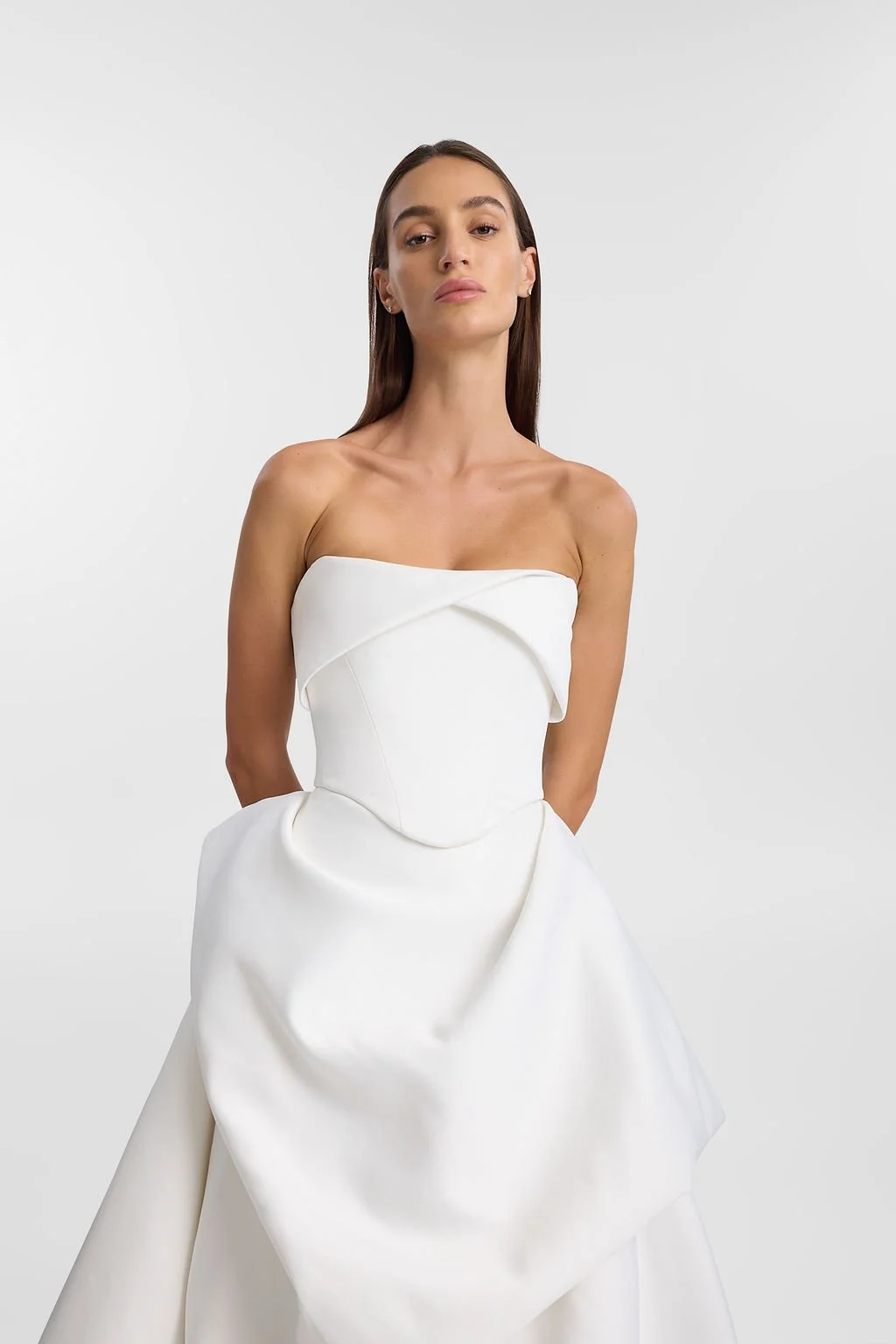 On cloud nine in KYHA Bride Lowe. Designed from lustrous duchess satin, Lowe’s bold focus on shape and head-turning structural draping creates soft, cloud-like moments. Featuring a sculpted waistband and a floor-grazing full skirt with internal netti