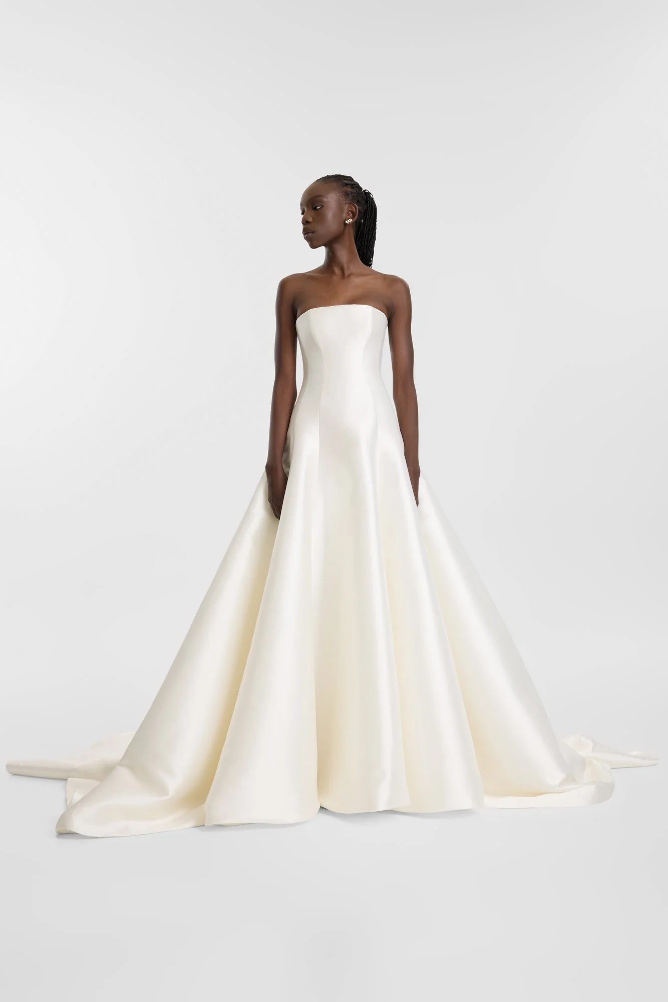 Contemporary couture meets nostalgic nuance in KYHA Bride Adler. Architectural in form yet fluid in movement, this strapless gown is cut from lustrous Mikado holds its sculptural shape. A clean, straight neckline sets creates a modern edge, while the