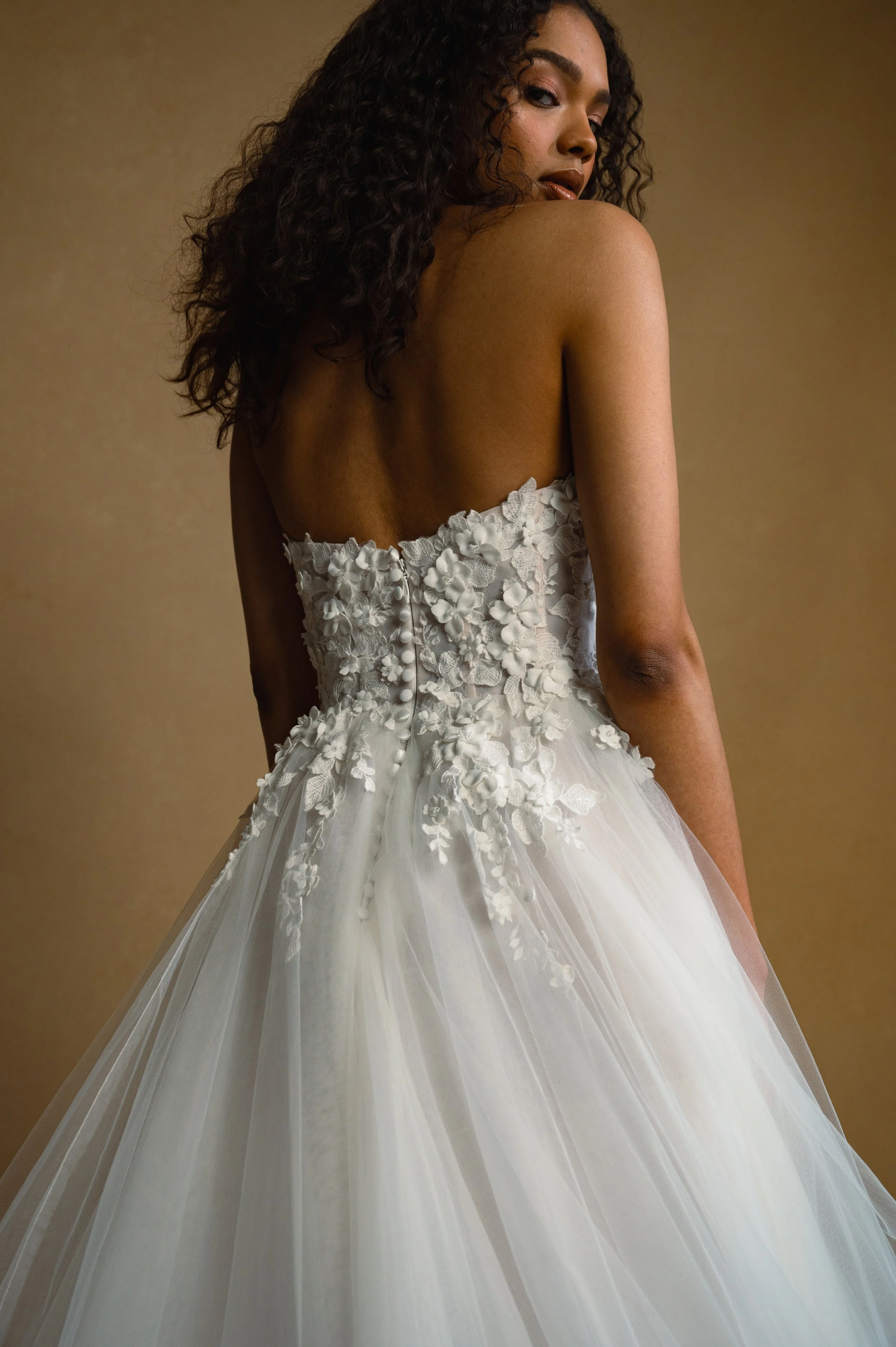 The Jenny Yoo Bridal Romy: Delicate yet dimensional floral appliques adorn a corseted bodice and lead to a full, frothy tulle skirt, the Romy gown is a true romantic. Stocked at Halo and Wren Bridal.