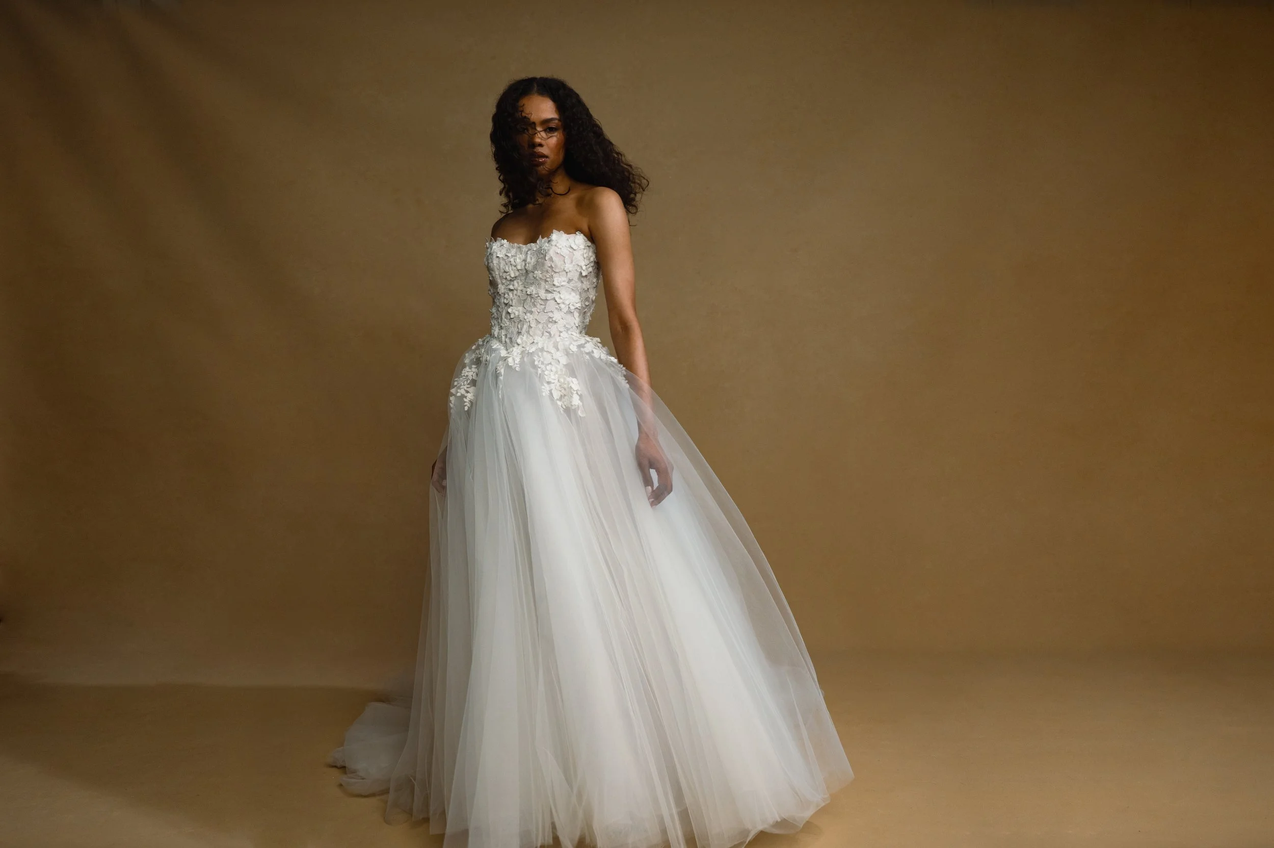 The Jenny Yoo Bridal Romy: Delicate yet dimensional floral appliques adorn a corseted bodice and lead to a full, frothy tulle skirt, the Romy gown is a true romantic. Stocked at Halo and Wren Bridal.