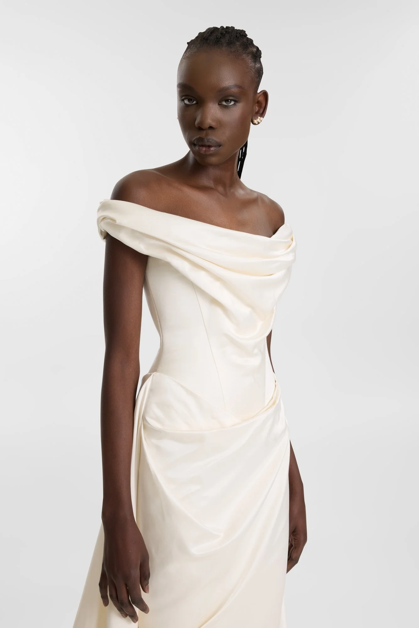 Past and present collide in KYHA BRIDE Blyth. Introducing a new and luxurious creamy silk satin, KYHA Bride Blyth gown is a fresh take on a classic. Its off-shoulder, draped and highly structured corset cinches the waist and its soft column front ski