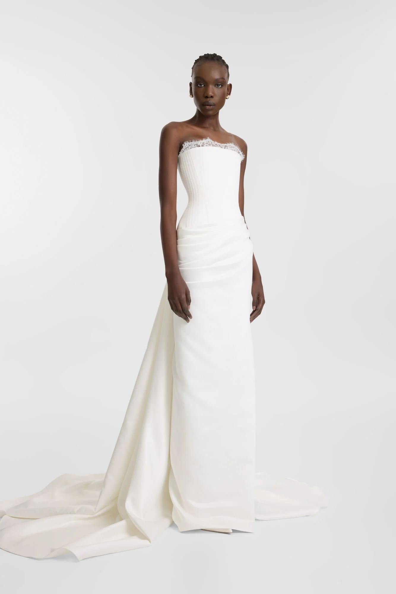 Celebrate the finer things in KYHA Bride Eaton. A structured drop waist bodice reveals fine details in a soft lace trim at the neckline and boning channels designed to draw in the eye. An asymmetric drape sweeps across the hip into a fluid column ski