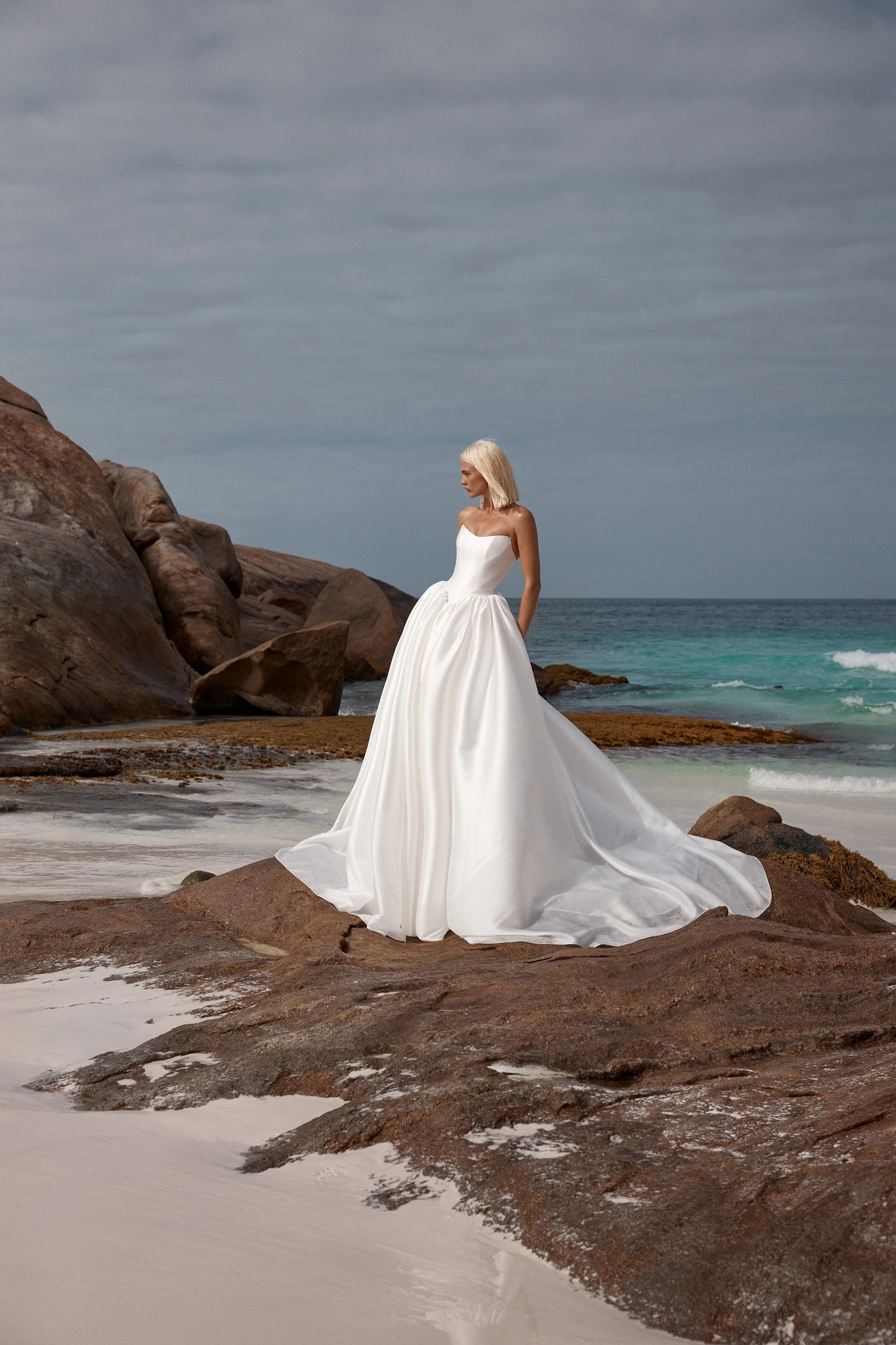 Dress like the queen that you are c/o KYHA Bride Miles. Crafted from a luxe woven taffeta, a gathered Basque waistline accentuates an hourglass shape made modern via a softly scooped neckline. Drama reigns supreme via the ballgown skirt, making Miles