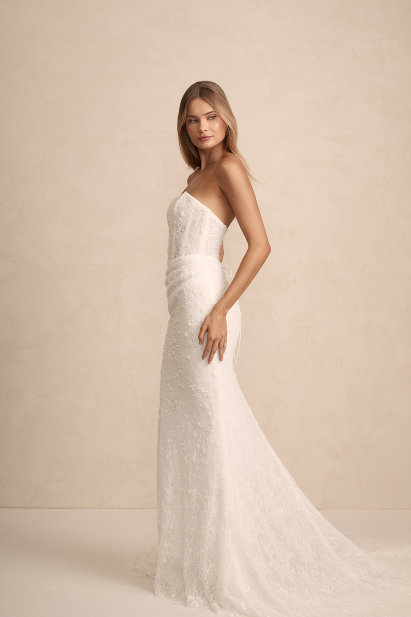 MWL Haven is made from the finest beaded Chantilly lace, with intricate eyelash lace trim details adorning the hem, adding a touch of elegance to her timeless design. Her corset back, complete with pearl-beaded ties, offers a perfect balance of detai