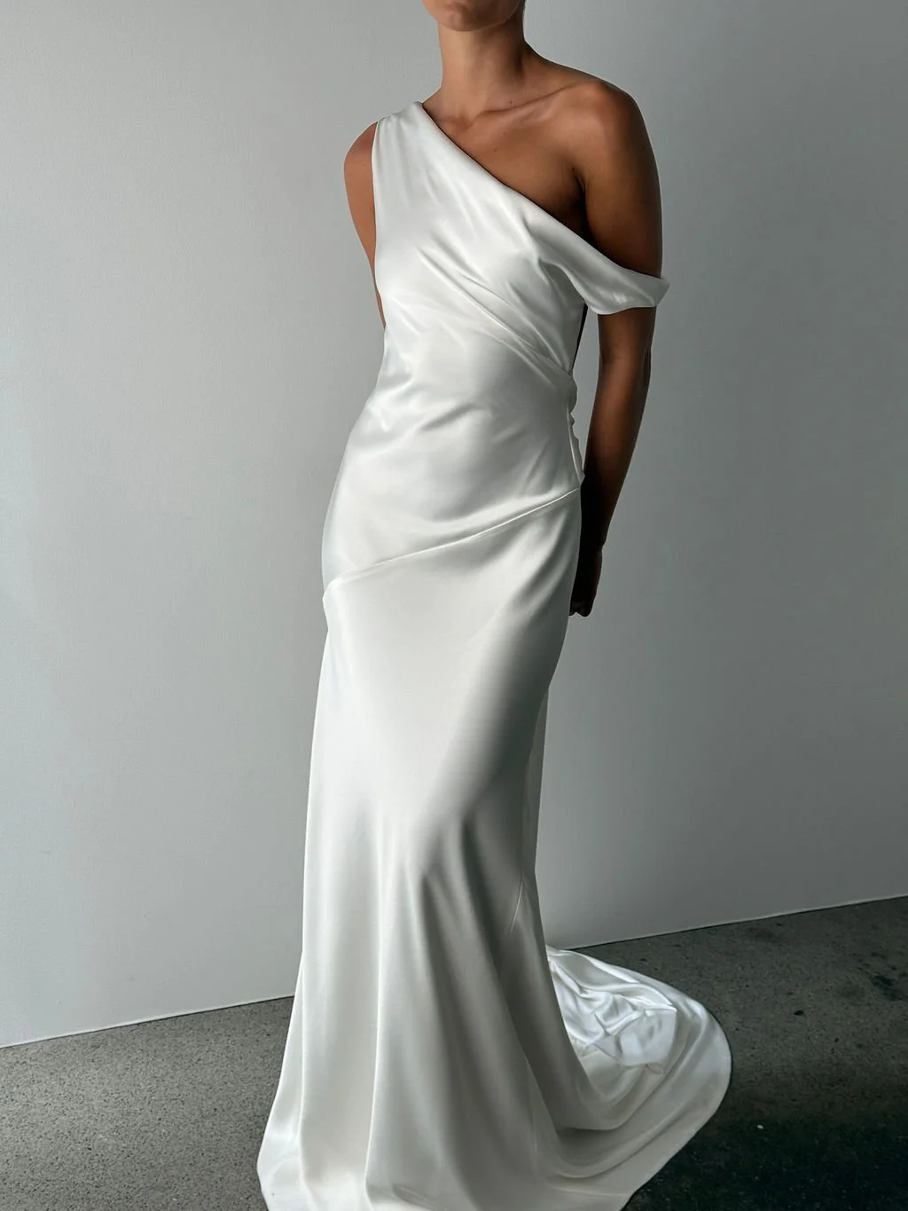 Effortlessness takes the lead in KYHA Bride Arlo. Cut on the bias, liquid double satin falls naturally over the body, delivering nonchalant energy with a distinctly modern edge. A clean, minimal off-shoulder front allows the open back to take centre 