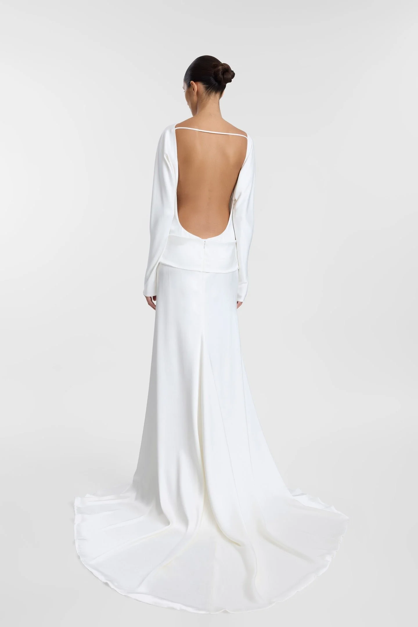 Meet KYHA Bride Lola, spirit of the 70s that will live in your head rent-free. Cut for a slightly oversized fit in luxe double satin, Lola features long batwing sleeves, a twisted sash at the hip, and a skirt with a soft train. The open back adds an 