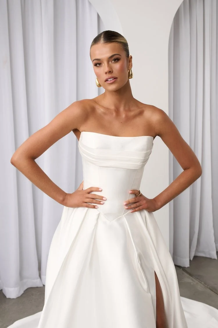 Jane Hill Bridal Anderson timeless meets modernity in Anderson. with a flattering elongated v-shaped corset and clean straight neckline, this gown is finished with our voluminous signature skirt in luxe mikado