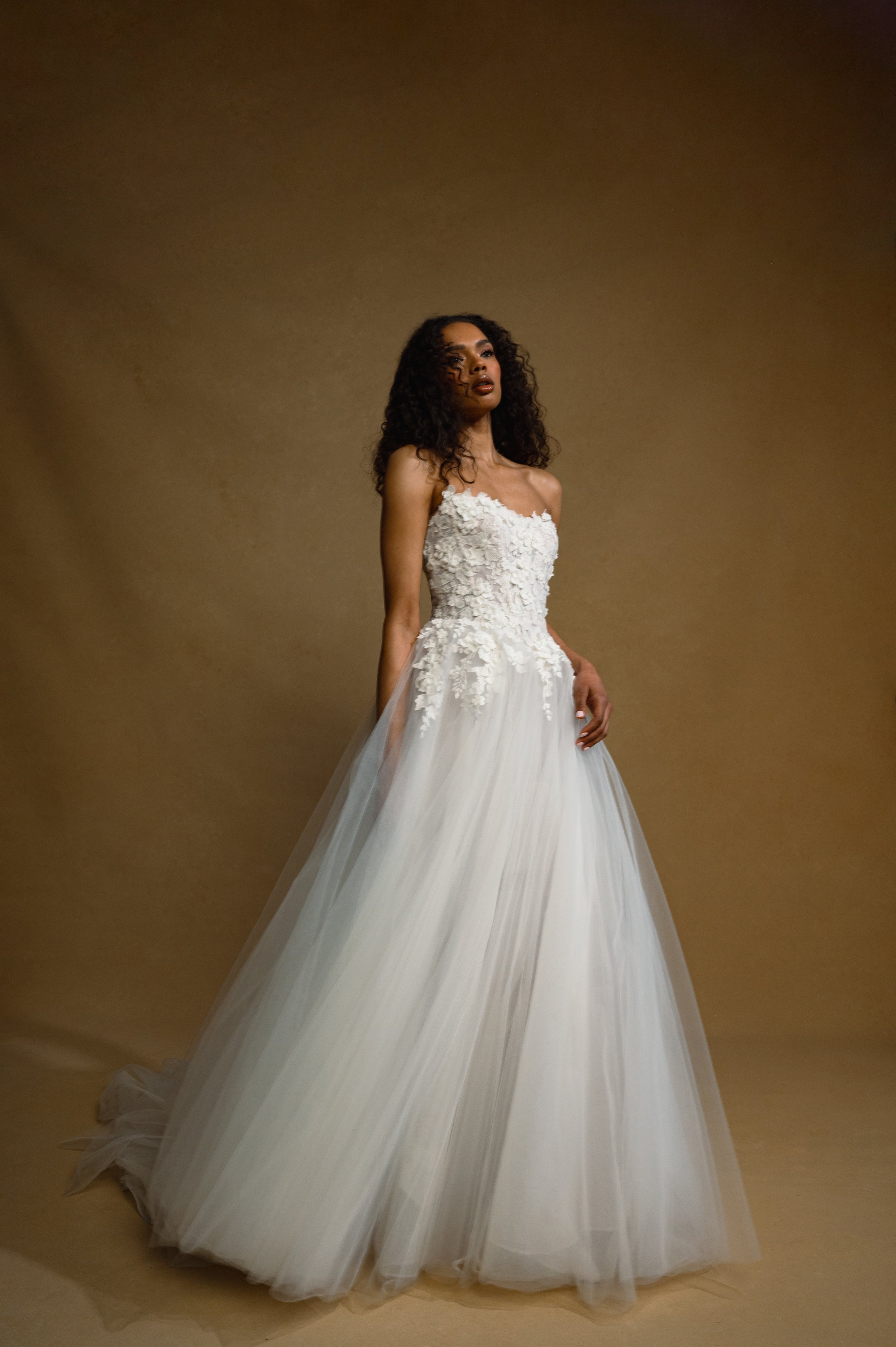 The Jenny Yoo Bridal Romy: Delicate yet dimensional floral appliques adorn a corseted bodice and lead to a full, frothy tulle skirt, the Romy gown is a true romantic. Stocked at Halo and Wren Bridal.