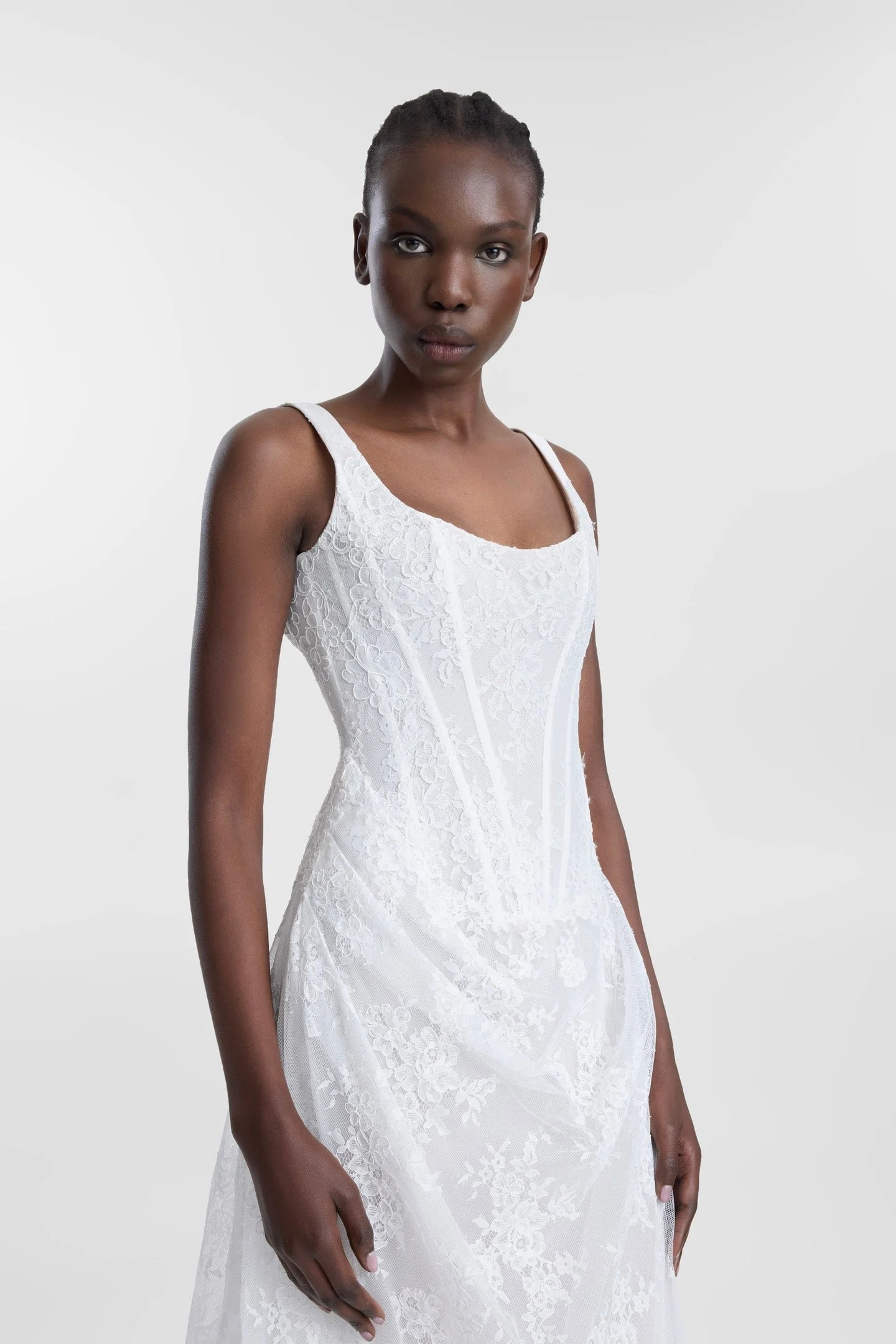Old world charm meets modern moments in Joni. Imbued with classic appeal, Joni features an A-line silhouette with a scoop neckline, a corseted bodice, shoulder straps and a draped skirt. Corded lace is sculpted across the bodice and effortlessly drap