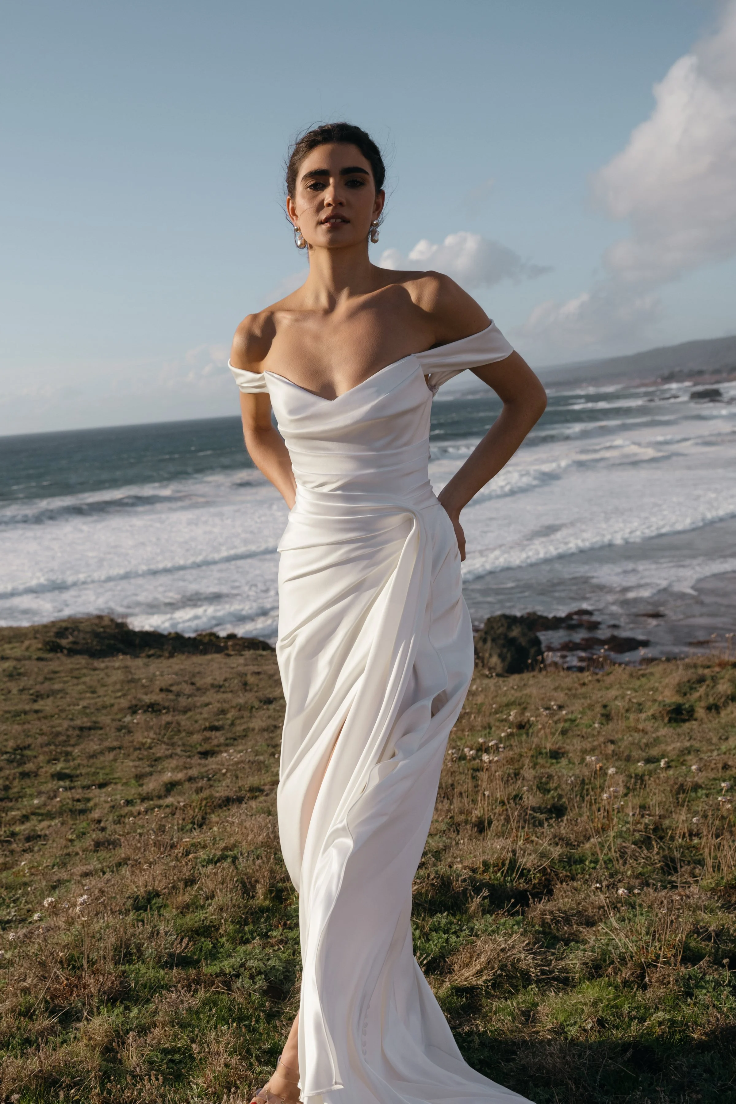 The Jenny Yoo Lana gown is a refined satin wedding dress cut in luminous Barcelona satin with elegant pleating and draping that flatters the figure, and it stands out for its versatile styling with removable long sleeves and optional sash sleeves tha