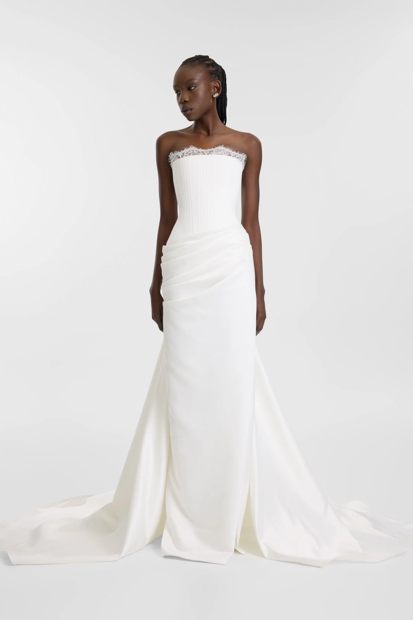 Celebrate the finer things in KYHA Bride Eaton. A structured drop waist bodice reveals fine details in a soft lace trim at the neckline and boning channels designed to draw in the eye. An asymmetric drape sweeps across the hip into a fluid column ski