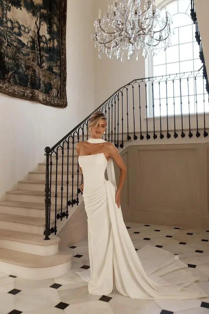 Jane Hill Bridal Mont Blanc is designed for the bride who loves clean lines with couture-level detail. The structured bodice features subtle texturing across the bust, flowing into a dropped waist that elongates the silhouette. Soft ruching sweeps ac